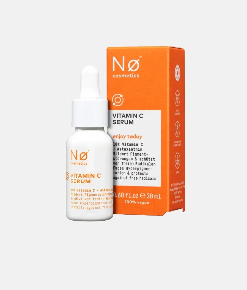 Nø cosmetics Vitamin C Serum in einer weißen Pipettenflasche neben der orangefarbenen Umverpackung.