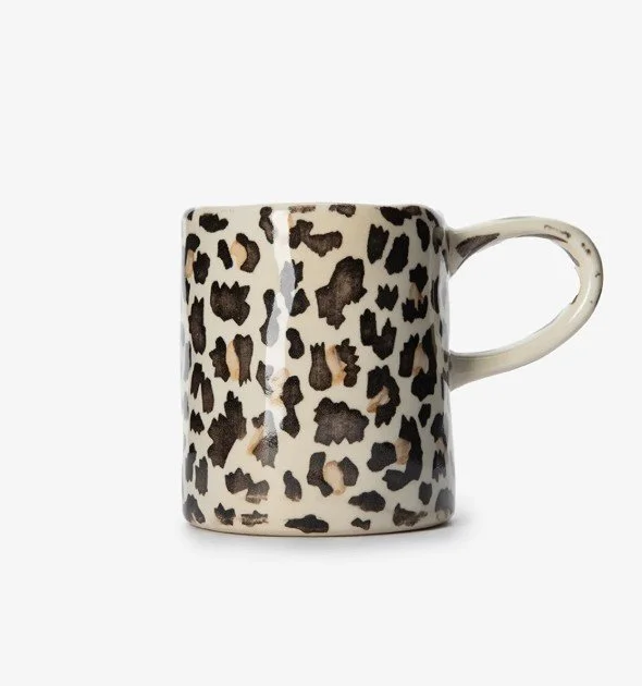 Keramiktasse mit Leopardenmuster in Beige und Schwarz als stilvolle Geschenkidee für Frauen, moderne Kaffeetasse mit Henkel auf weißem Hintergrund.