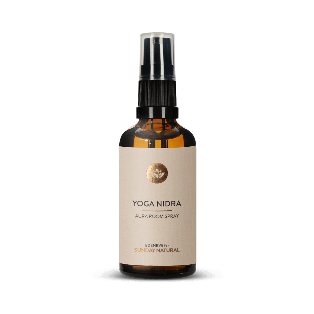 Braune Glasflasche mit schwarzem Sprühkopf. Auf dem hellen Etikett steht in Schwarz und Gold "YOGA NIDRA AURA ROOM SPRAY" von "EDENEVE for SUNDAY NATURAL".