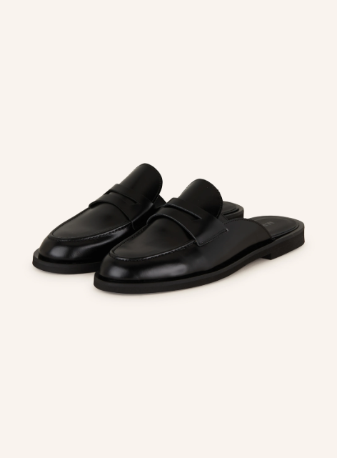 Schwarze, flache Mules aus Glattleder im klassischen Penny-Loafer-Stil.