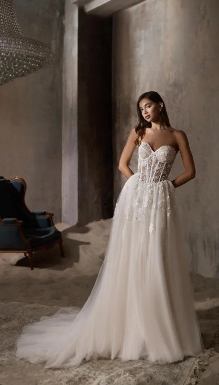 Romantisches, trägerloses Brautkleid mit Herzausschnitt, transparenter Spitzenkorsage (Corset-Look) und weitem Tüllrock mit Spitzenapplikationen.