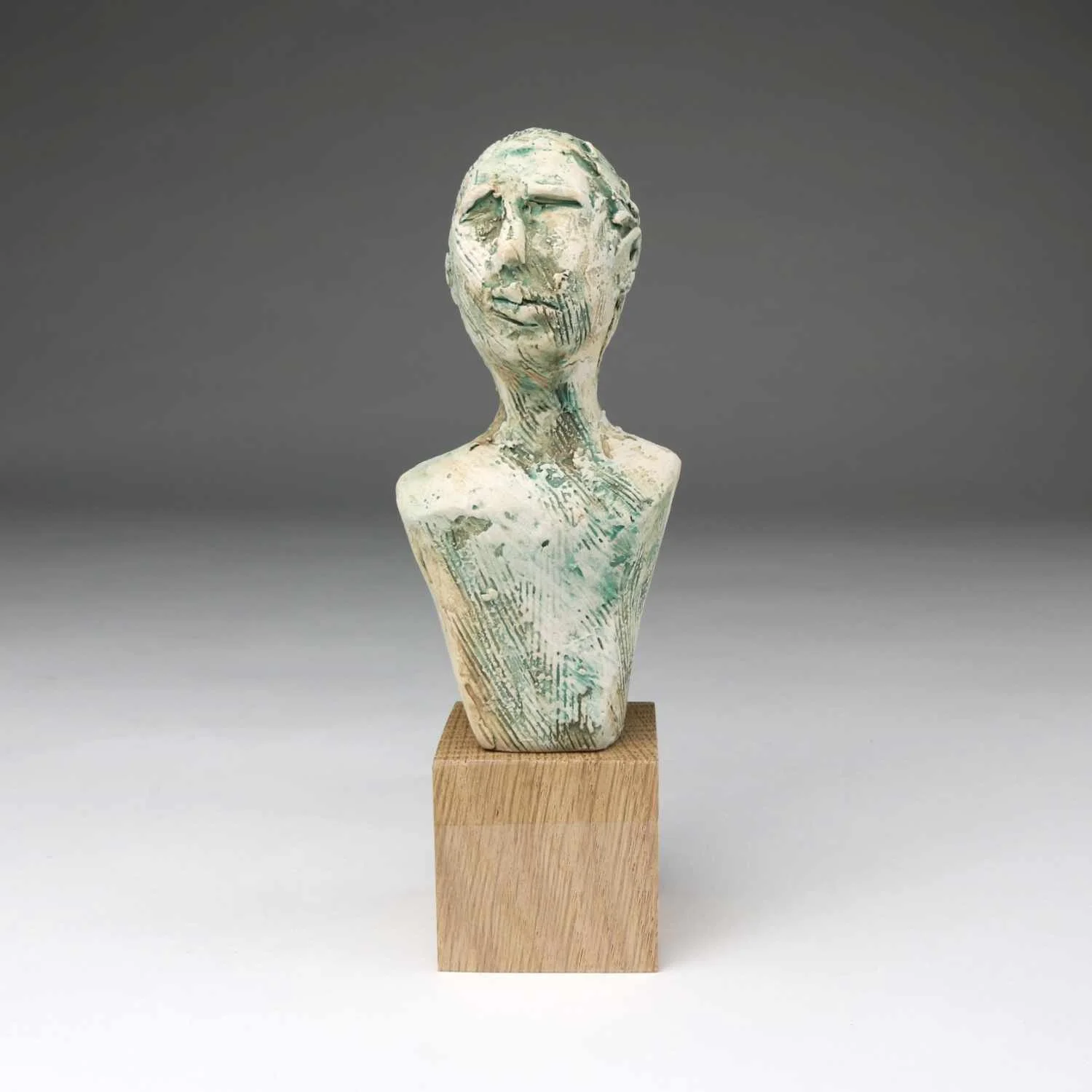 Discern, a green ceramic bust by Lisa Hilton with expressive facial detail and textured surface from the Women in Conversation collection.