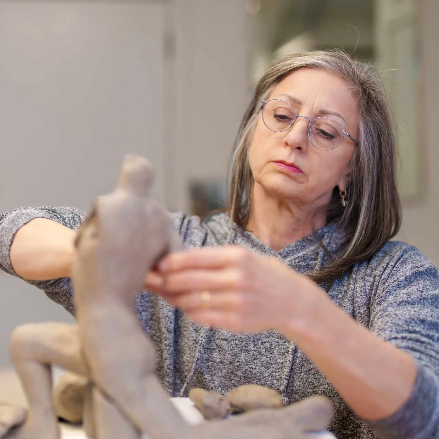 Lisa Hilton shaping a ceramic sculpture in her studio, exploring form, gesture, and surface