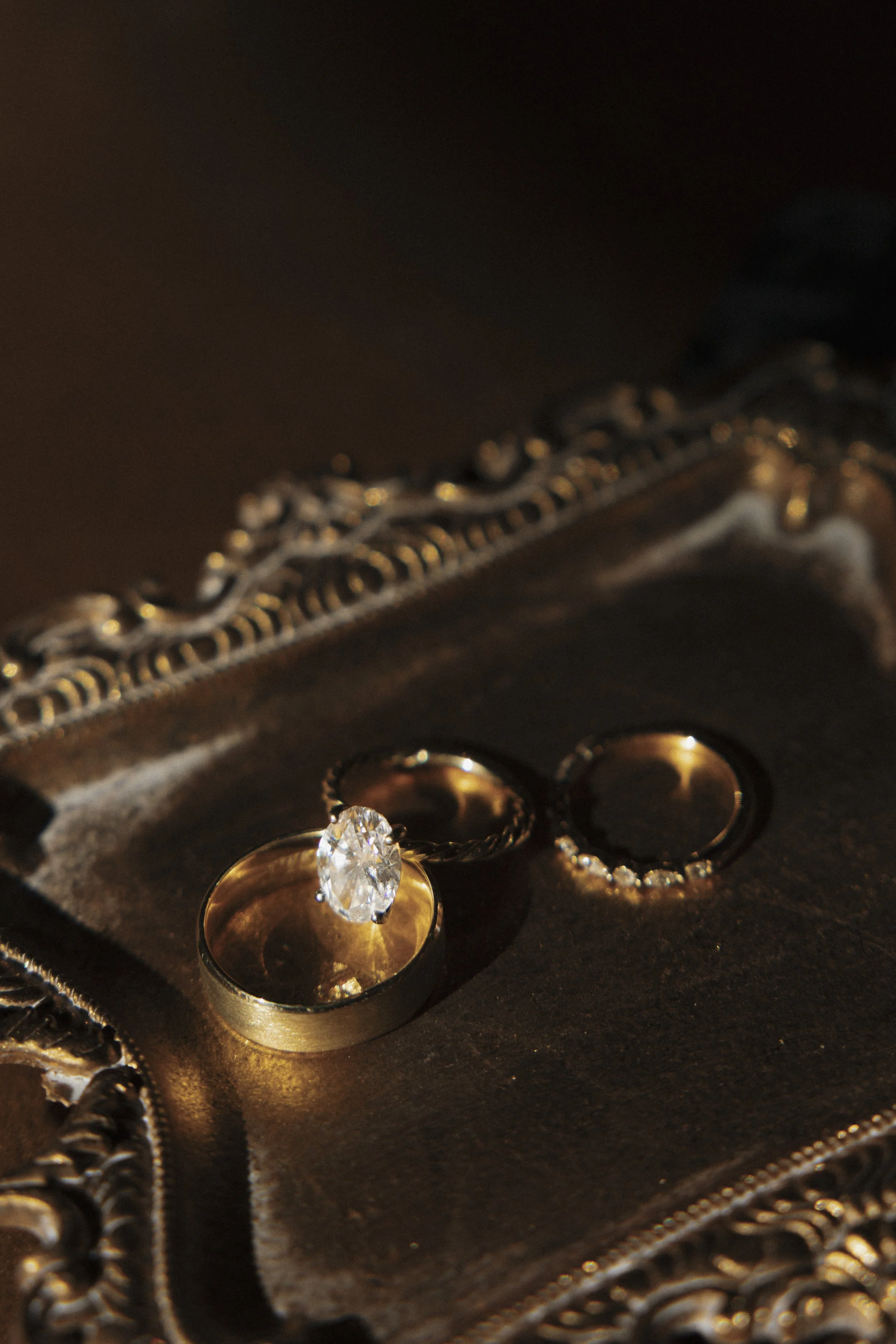 Close-up of wedding rings with a large diamond, placed inside an ornate jewelry box.