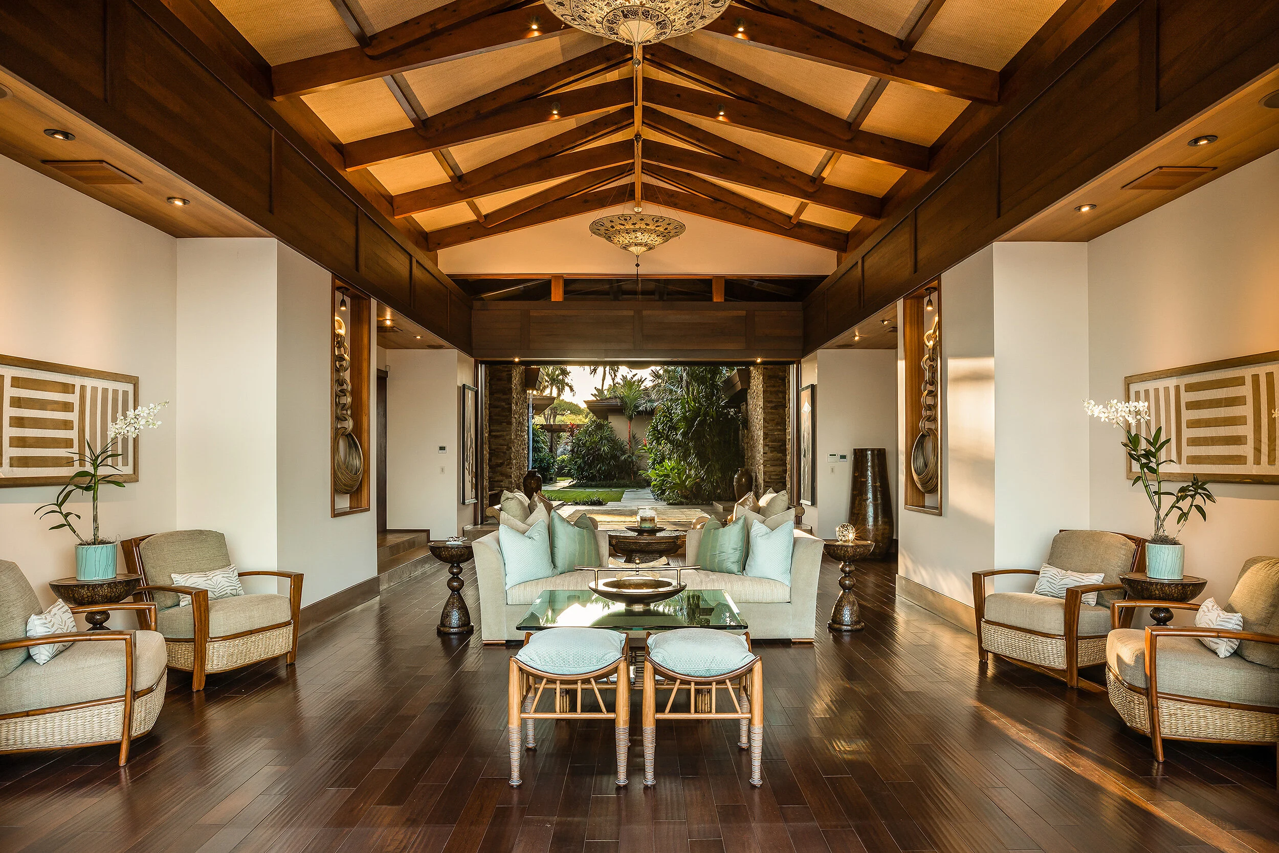 Great room displays elaborate vaulted ceiling with indirect cove lighting in soffits, framed mill-work and hardwood inlaid flooring.