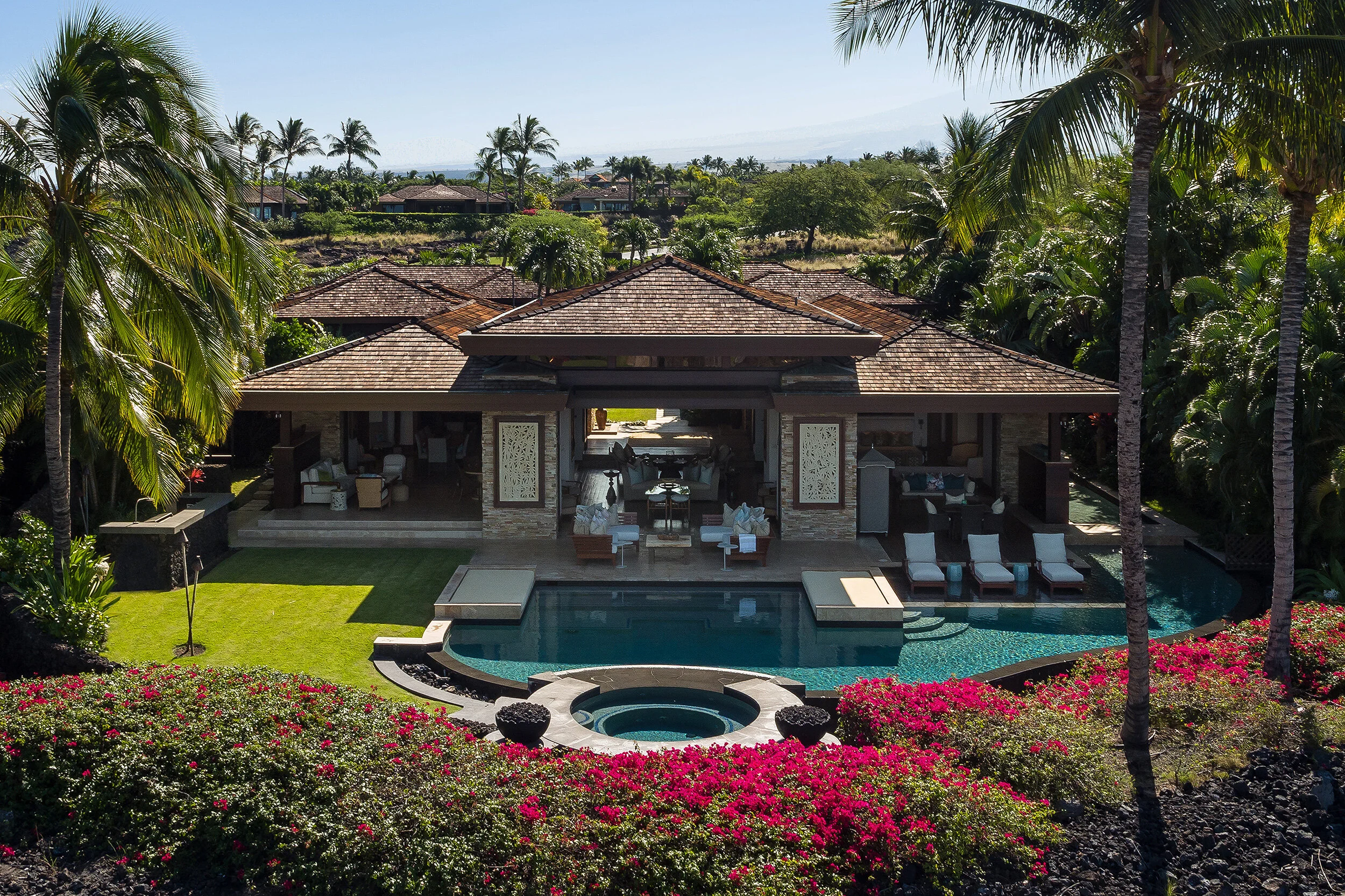 Magnify outdoor living with various seating options under the covered lānai. Enjoy the built-in barbecue station with refrigerator and prep sink, spacious lawn and inviting pool.