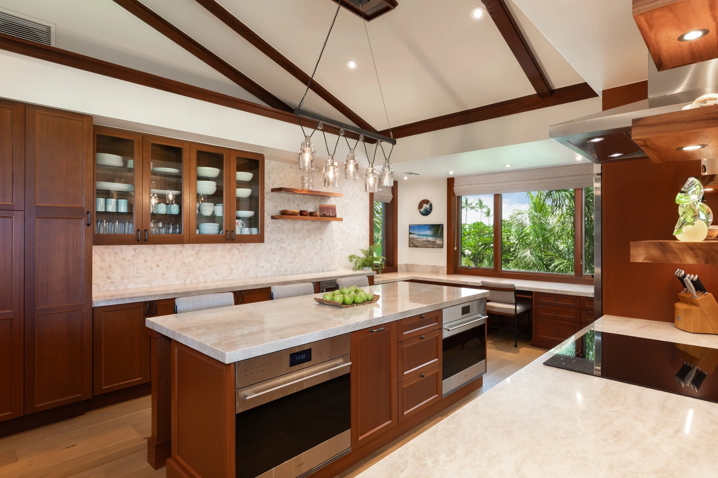 Large kitchen offers center island, built-in desk, and bar counter seating.