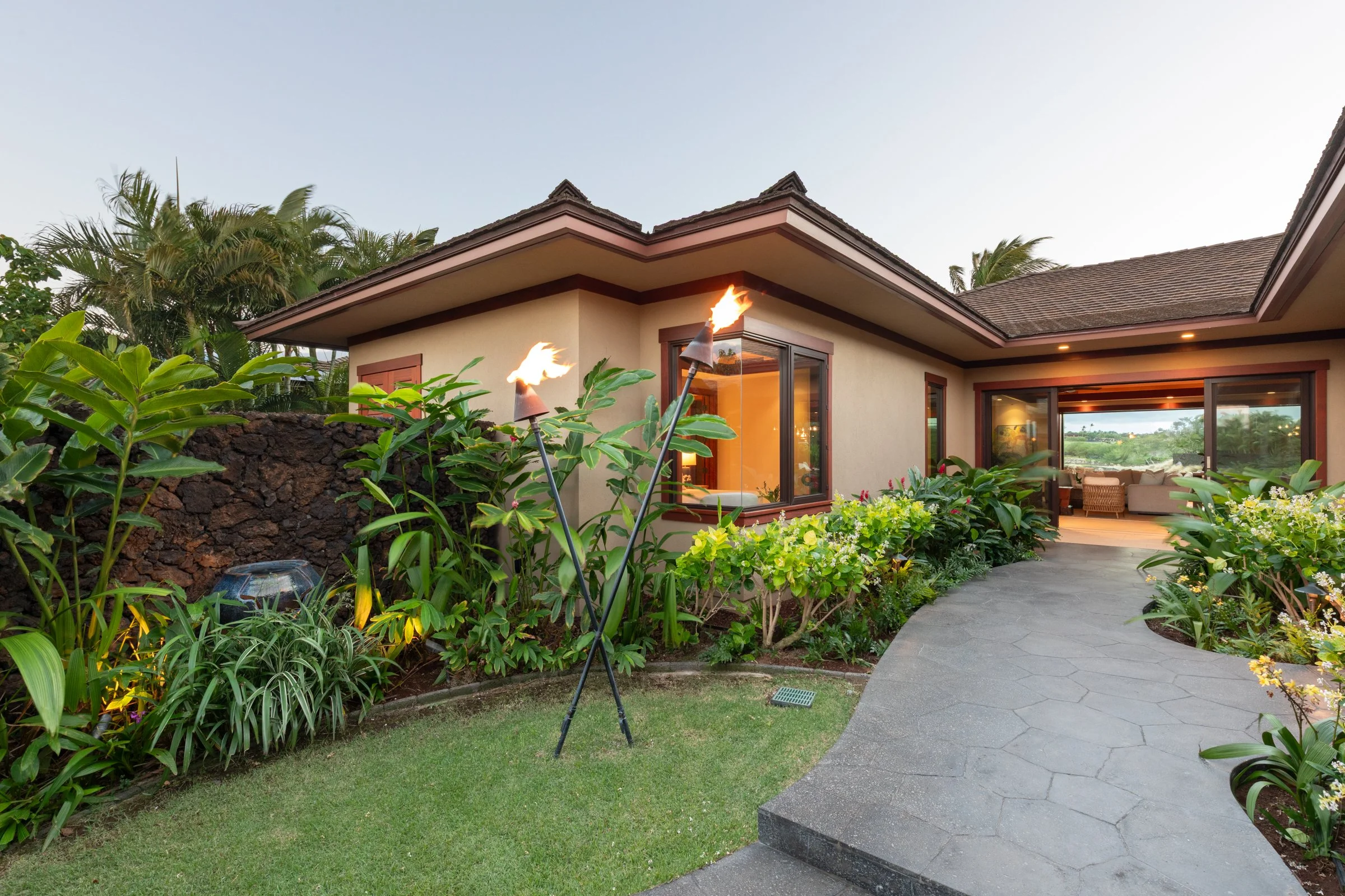 Private courtyard tucked behind a gated entry framed with Hawaiian quilt lava rock.