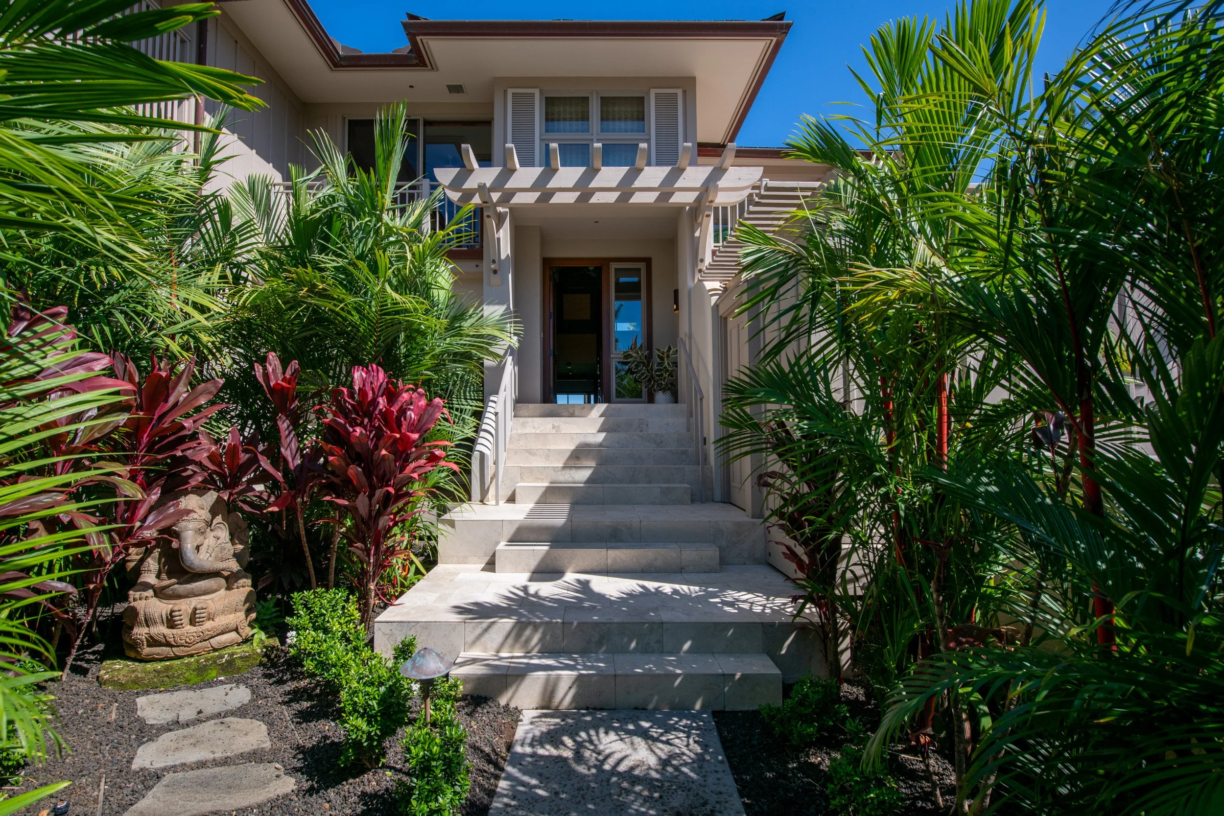 The upgraded, lush landscaping at the villa's entrance forms a tropical oasis along the walkway and at the entrance.