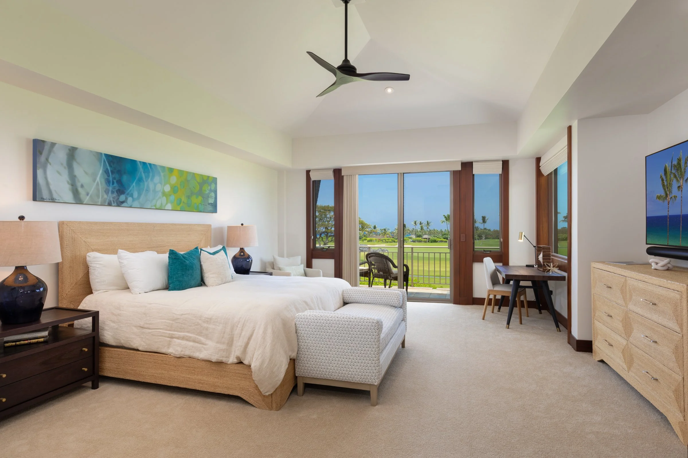 Primary bedroom features multiple windows for an abundance of light and a private lānai that offers ocean and golf course views.