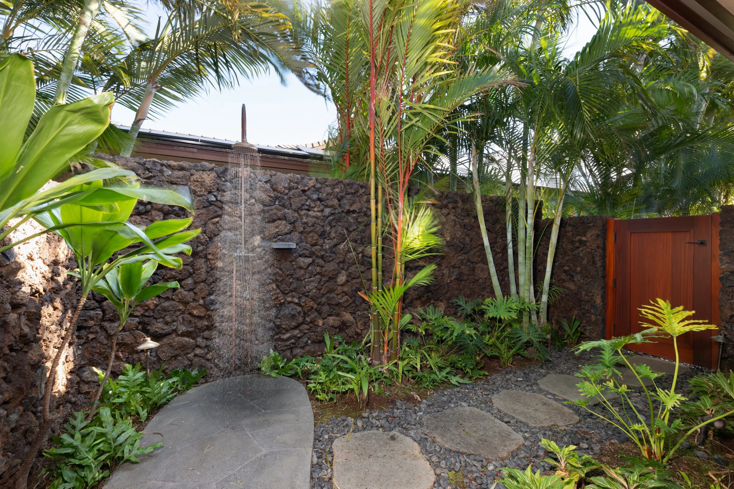 Primary bathroom features a tropical landscaped outdoor shower garden, one of four in the home.  