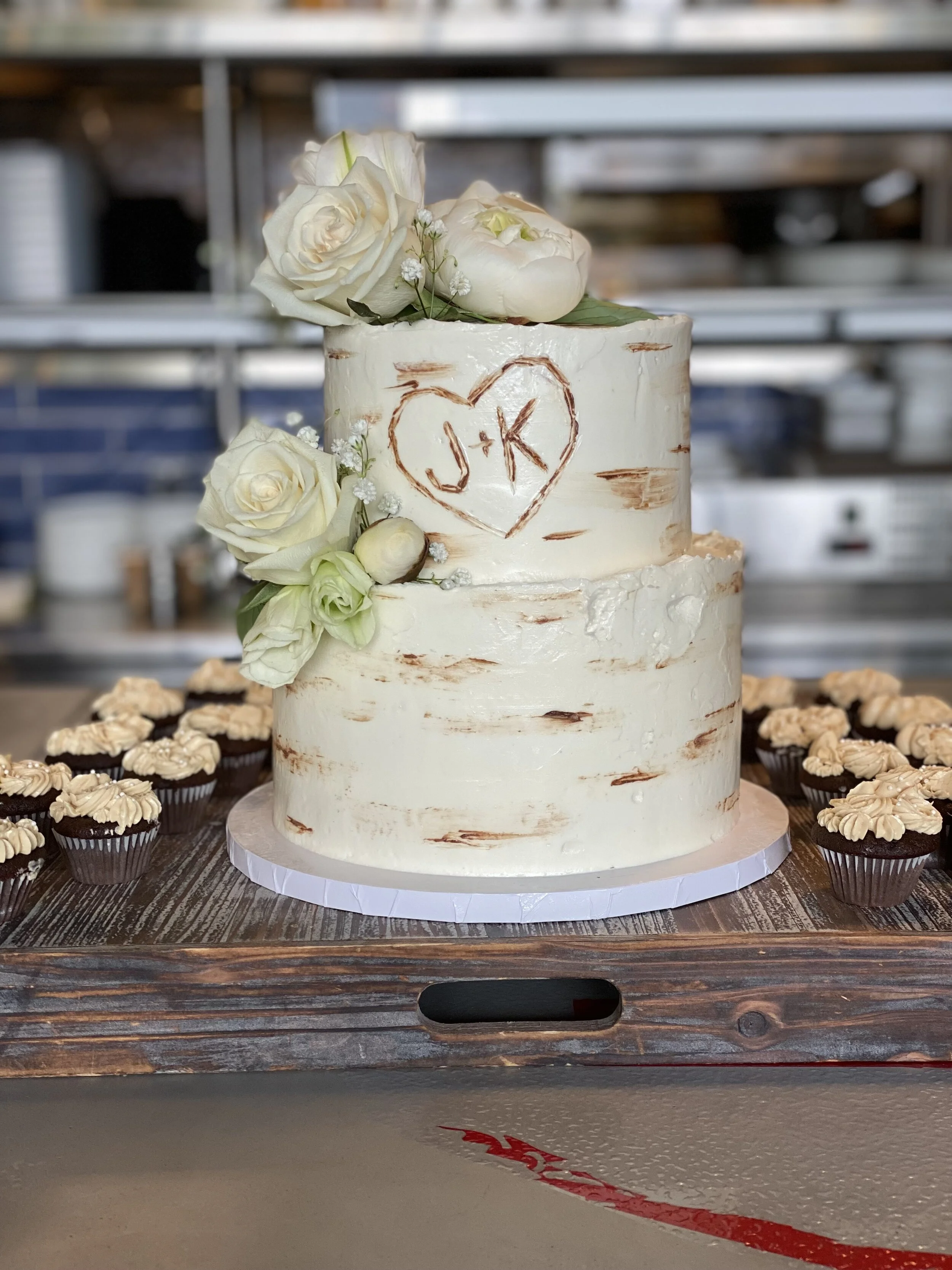 Two-tiered cake with pine inspired look for a bridal shower! Accompanied with mini chocolate cupcakes and salted caramel buttercream.