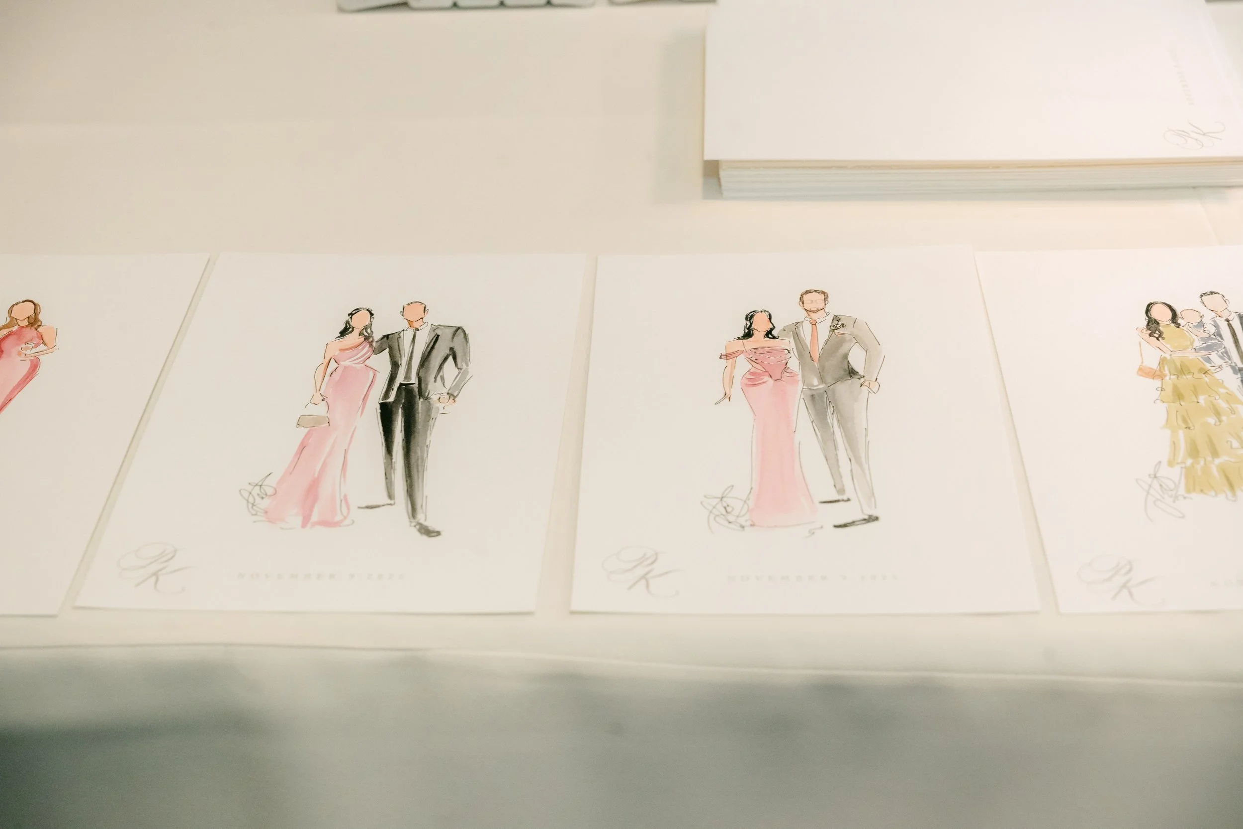 A display of illustrated wedding fashion sketches, each showing a couple in formal wedding attire, including a woman in a pink dress and a man in a suit, with some sketches featuring a woman in a yellow gown.