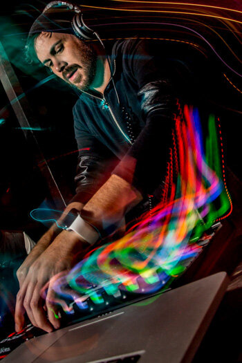 DJ using turntables with trails coming from lights