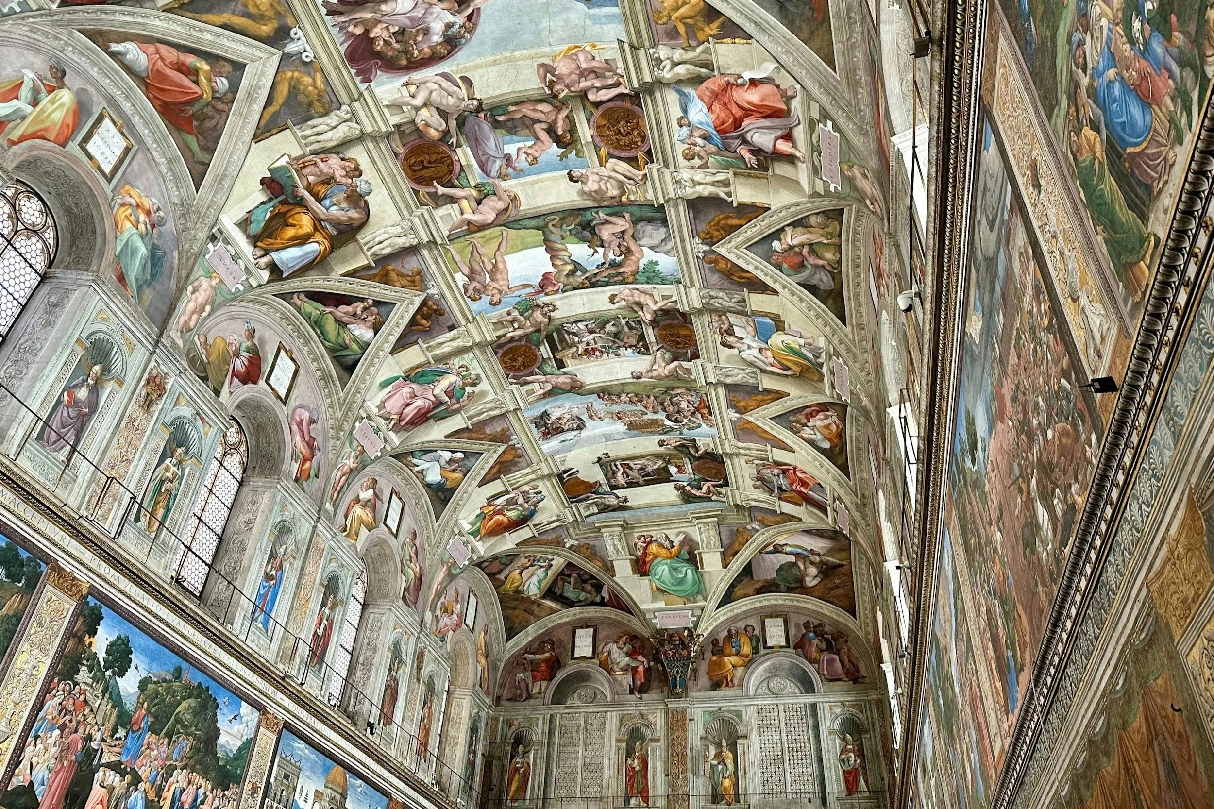 Intricate Michelangelo ceiling frescoes and Renaissance wall murals inside the Sistine Chapel at the Vatican Museums in Rome.
