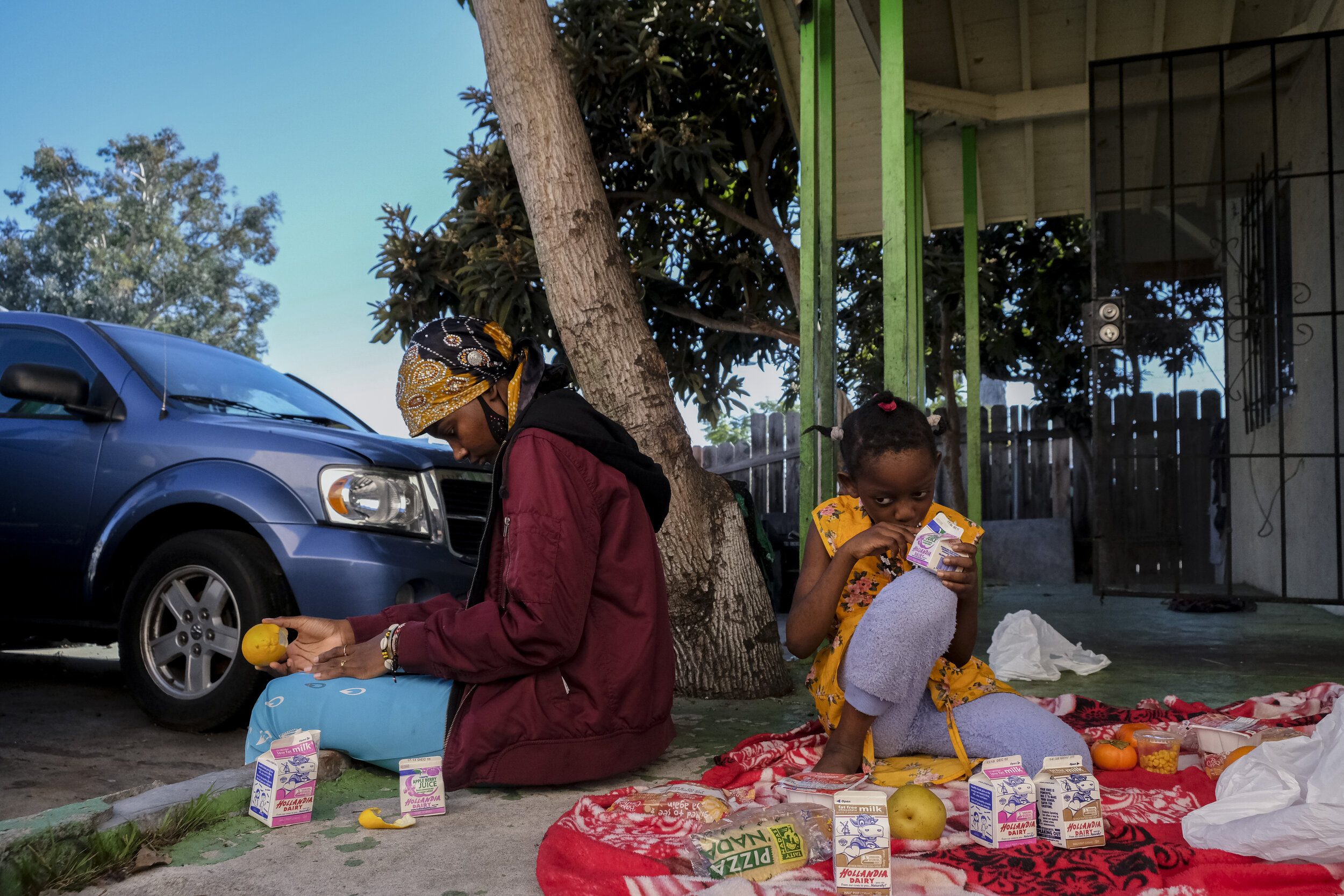  USA, San Diego, CA, December 1, 2020.&nbsp; Famo, 31, and her daughter Sadiya Musa, 7, picnic on their porch with lunches provided by San Diego Unified School District. The family picks up meals for a chance to take a break outside after the childre