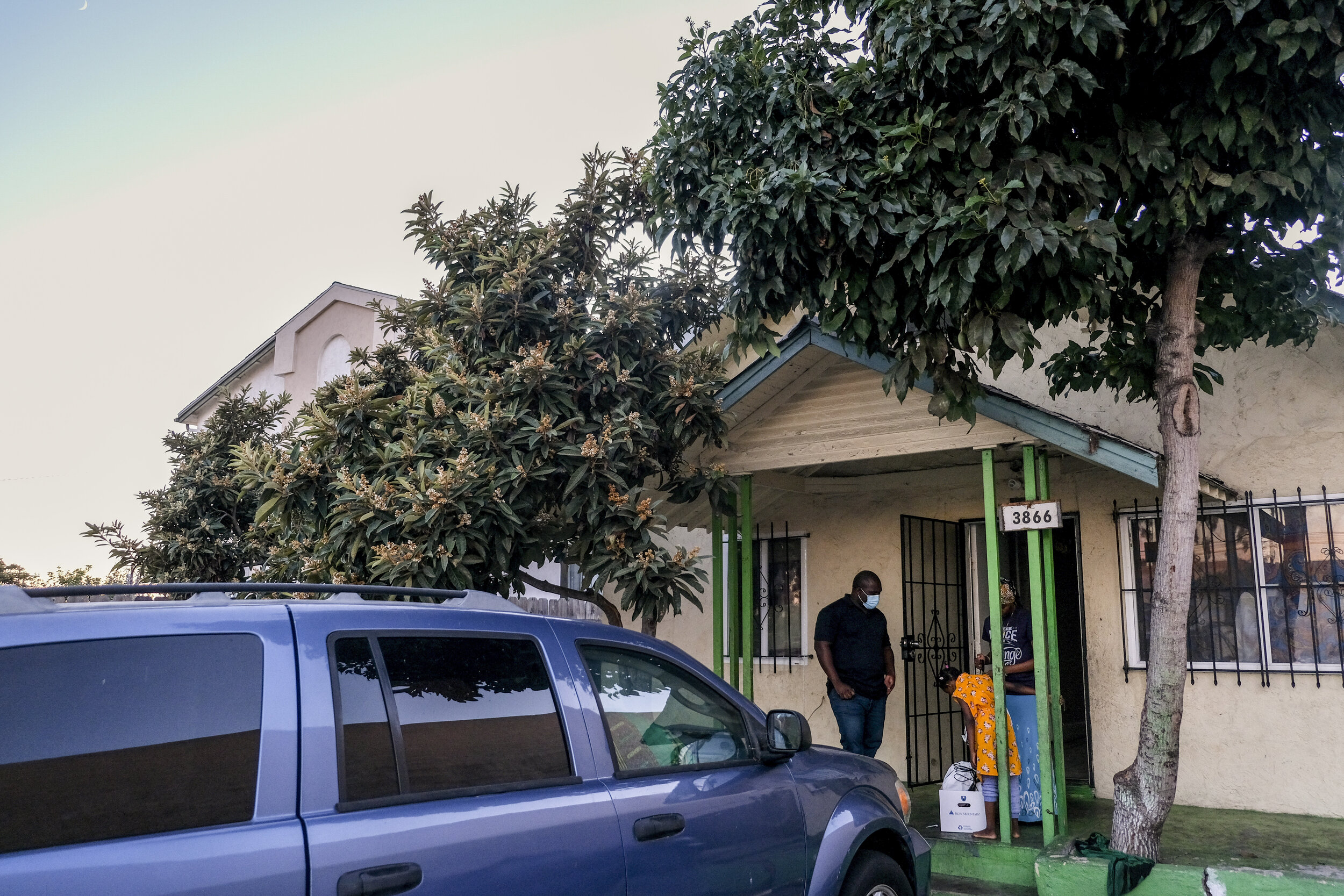  USA, San Diego, CA, December 1, 2020. Daniel Nyamangah, a Community Organizer at Parent Student Resident Organization (PSRO), delivers diapers and school supplies to Musa at dusk. They met when Musa was a high school student and became involved in P