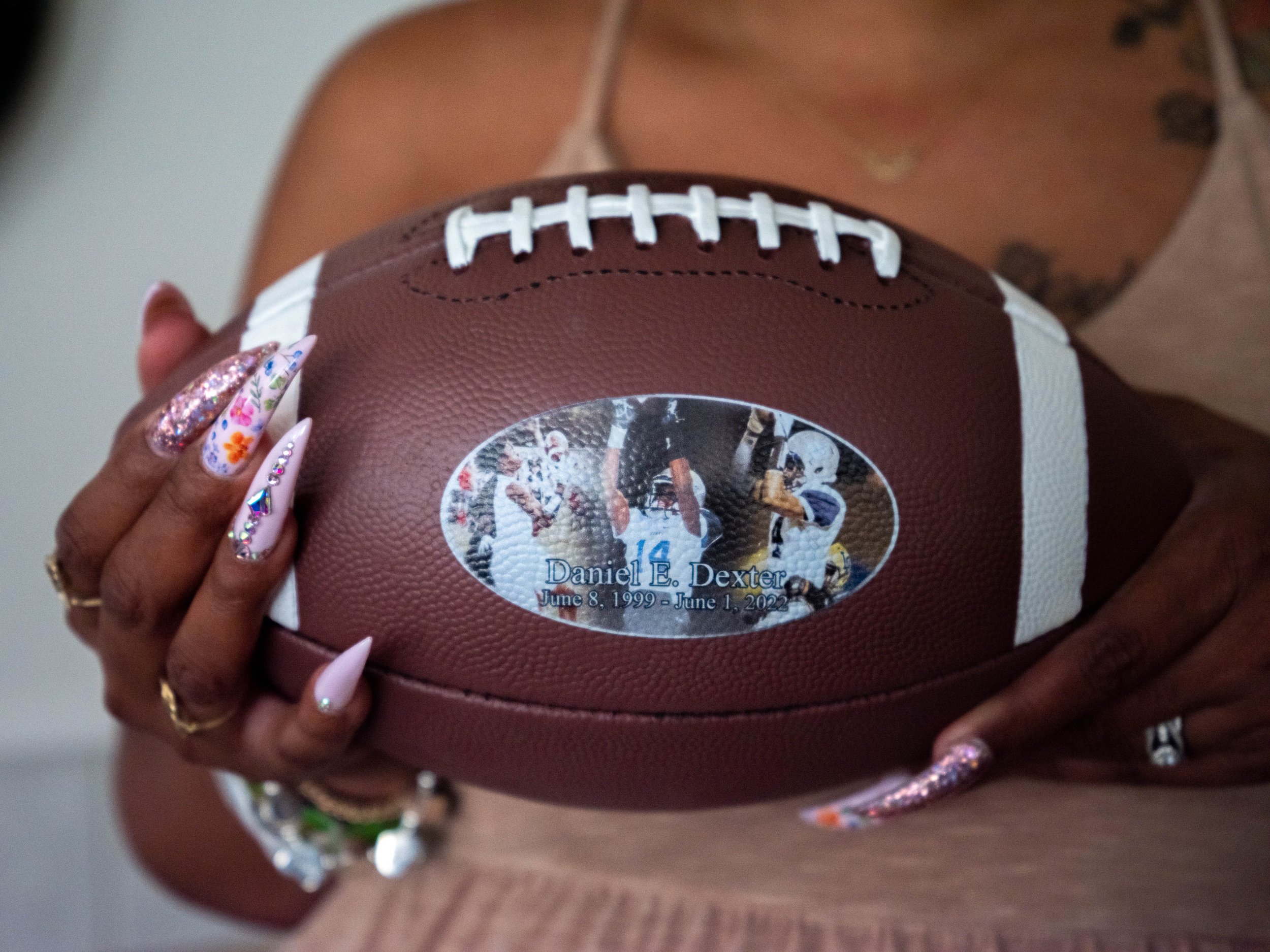  Daniel’s mother, Lauren Taylor-Mayweather, holds a football-shaped urn containing Daniel’s ashes on July 29, 2022. Football was one of Daniel’s passions and he was an “outstanding” linebacker and teammate for Victorville’s Silverado High School. (Ar