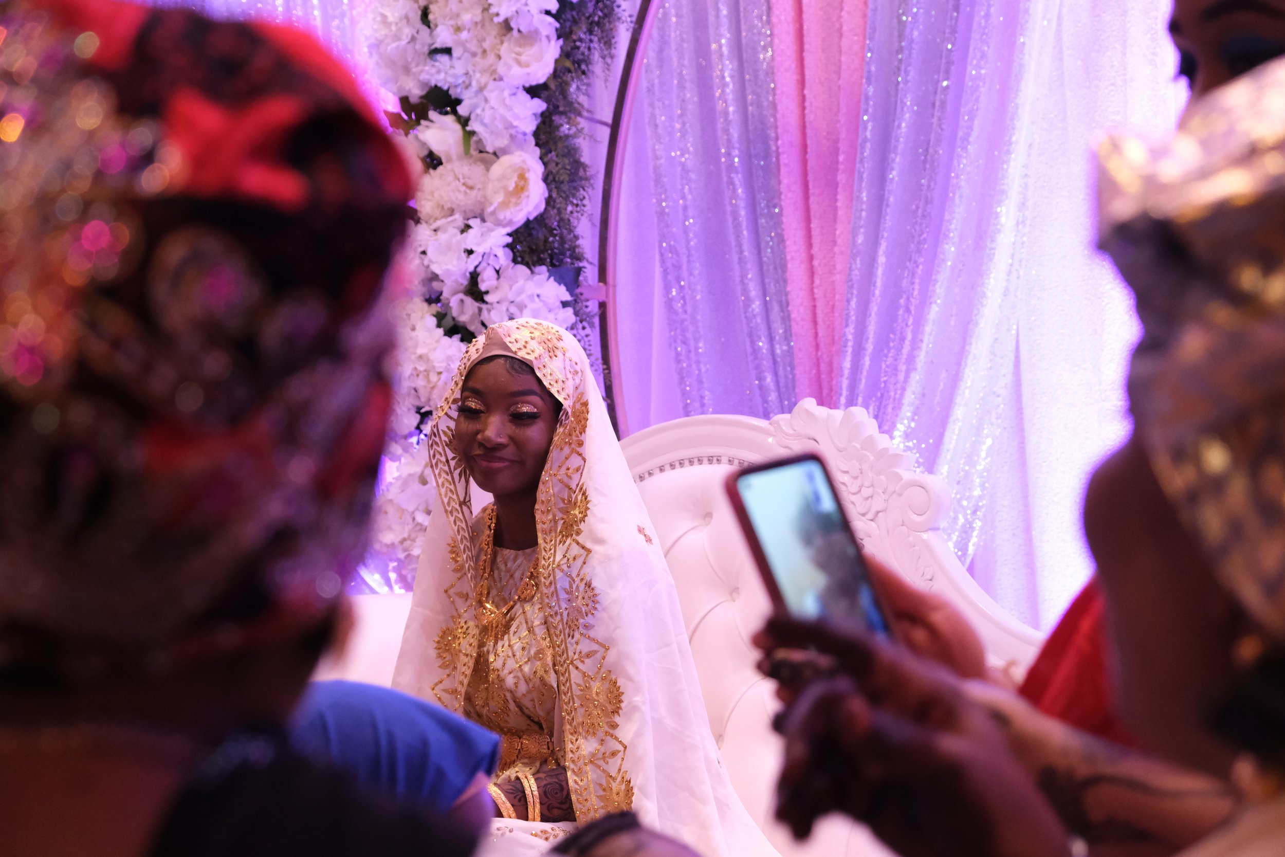  Famo Musa sits on the stage at her wedding while relatives take her photo on December 24, 2021. Musa, a Somalian refugee, challenged the narrative commonly set for women within her community by leaving her first arranged marriage and studying at UC 
