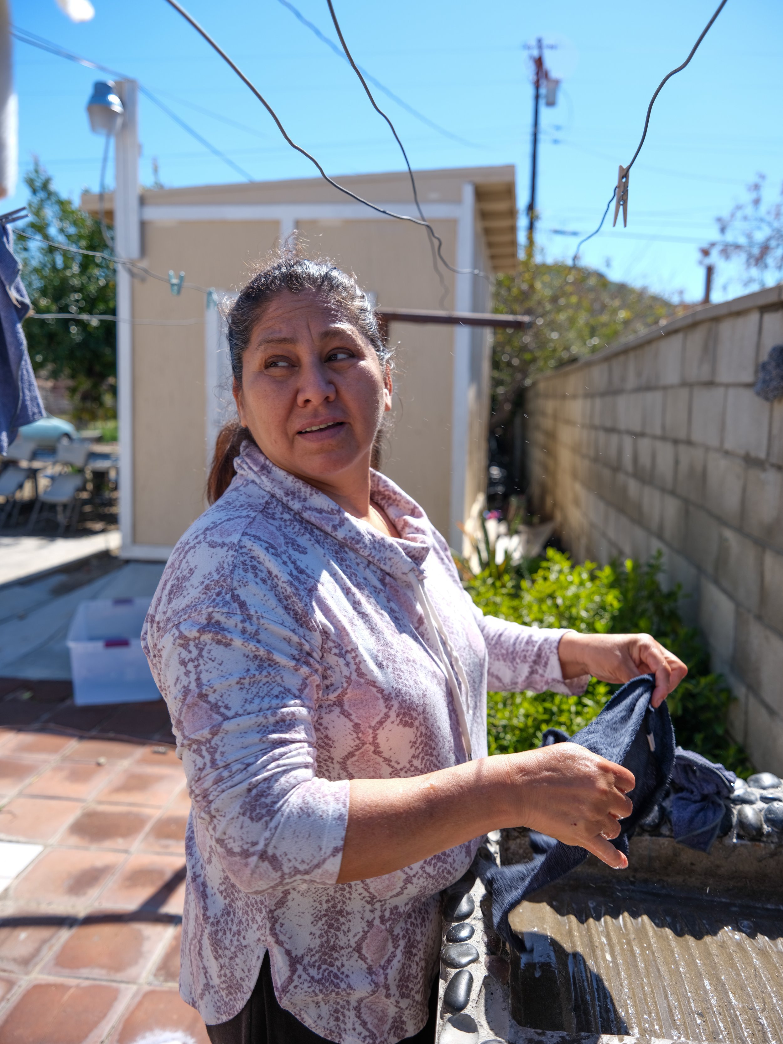  María  washes kitchen rags in a lavadero in her backyard on March 2, 2023. She said the lavadero and her yard among other things in the family home remind her of her home in Chiapas, Mexico. Years ago, her family moved from Los Angeles to Bloomingto