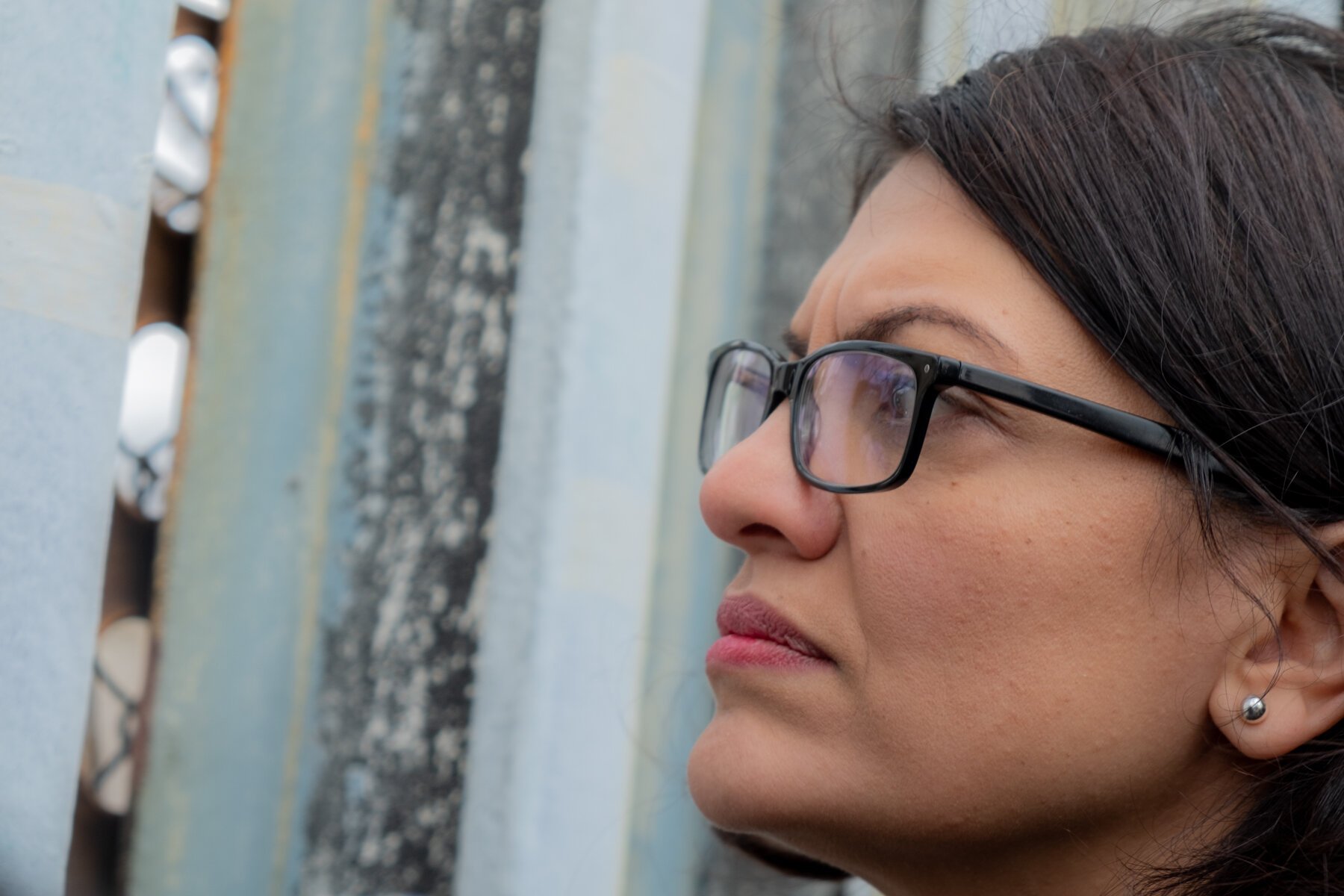  Congresswoman Rashida Tlaib looks across the U.S. Mexico border wall as she meets with deported veterans during her visit to Friendship Park in Playas de Tijuana, Baja California, Mexico on December 23, 2019. ©Aryana Noroozi 