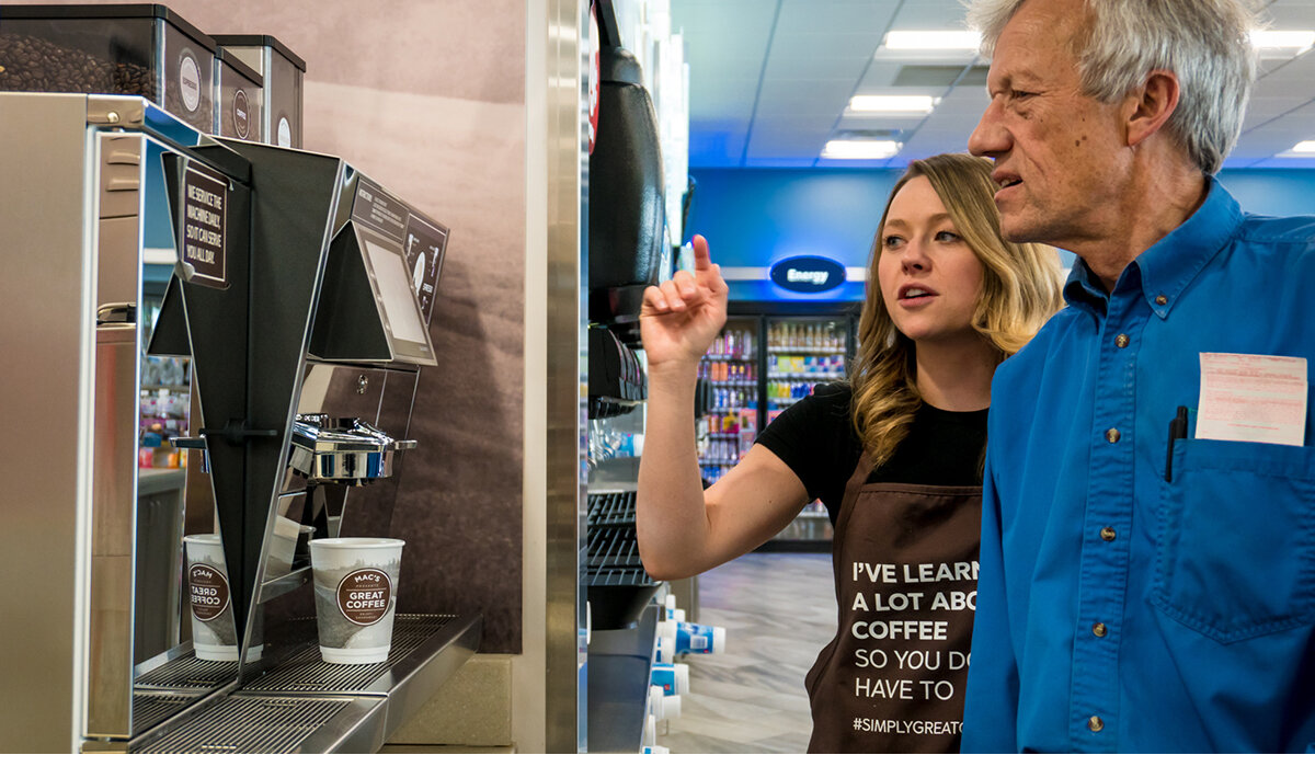 A brand ambassador assisting a customer with his coffee choice at the brand activation