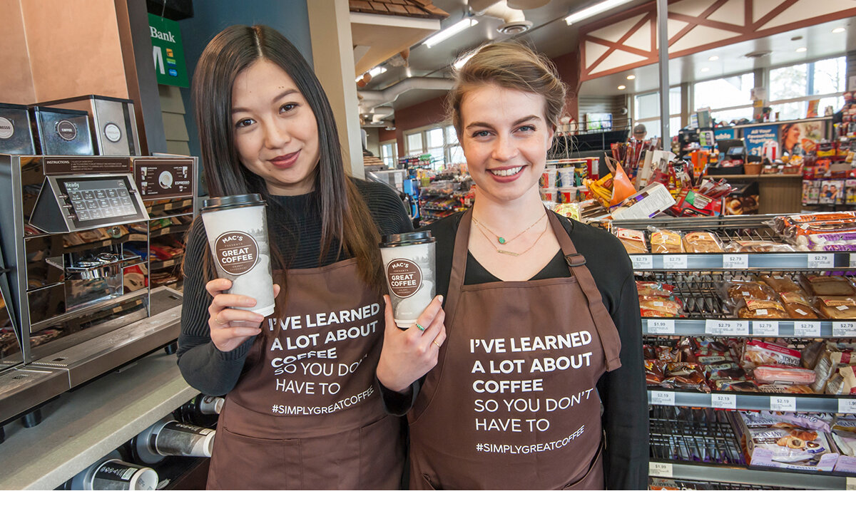 Two female brand ambassadors holding up two coffee cups.