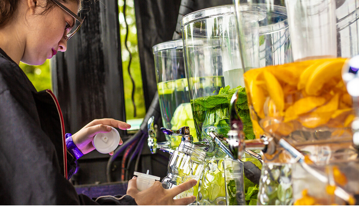 Female festival goer filling up her water bottle at the Vype brand activation at Skookum Festival in Vancouver, Canada
