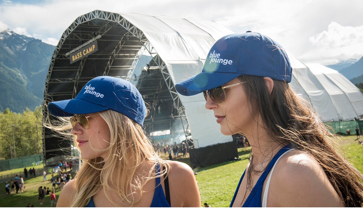 2 brand ambassadors wearing blue branded hats enjoying the music festival 