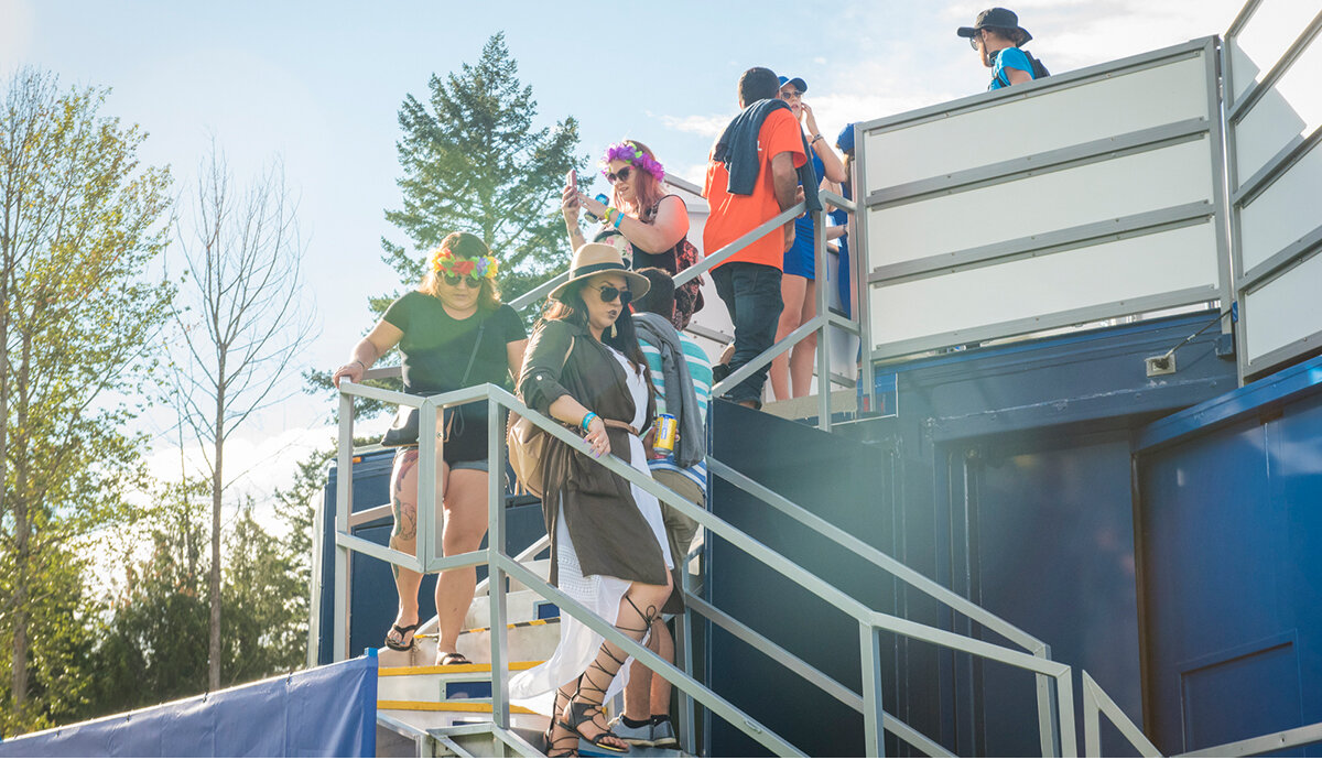 Festival goers, dressed in summer clothing, walking down the stairs at the Blue Lounge brand activation 