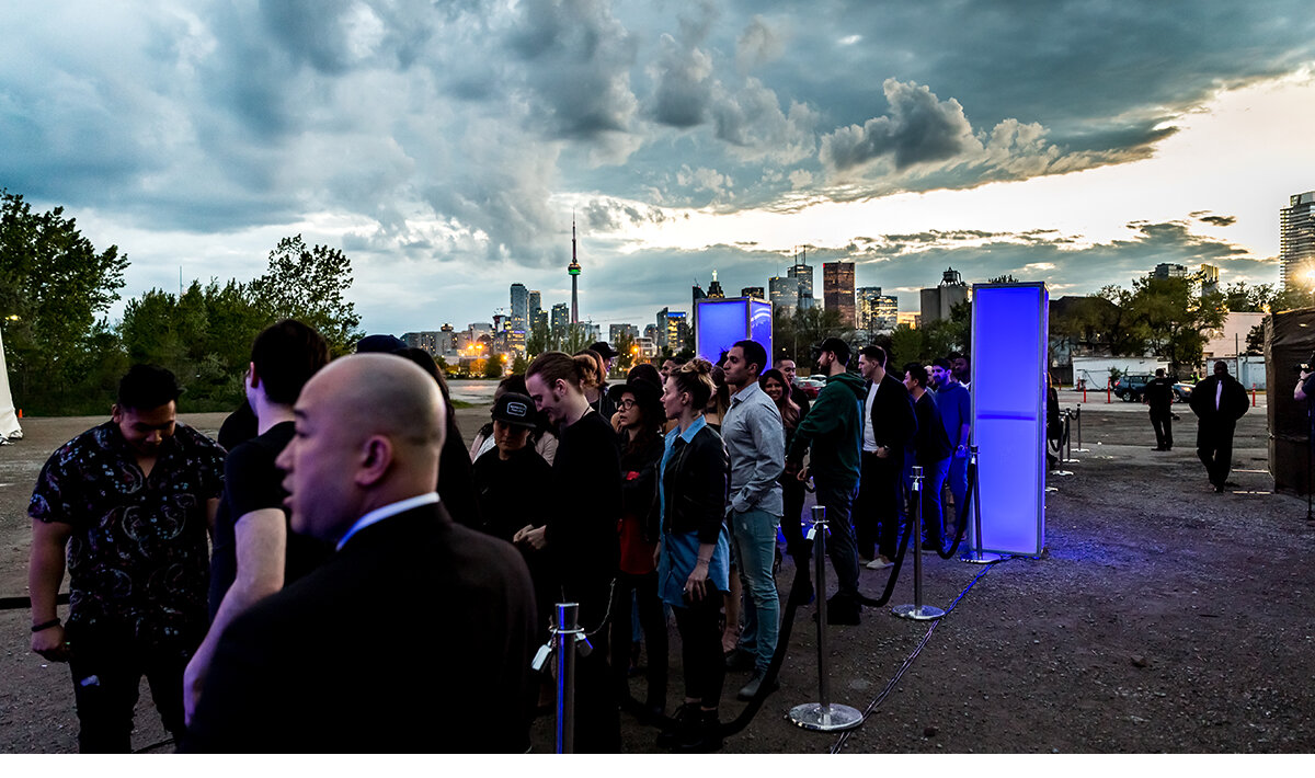 Guest lining up to enter the invite only industry trade event with Toronto skyline in the distance. 
