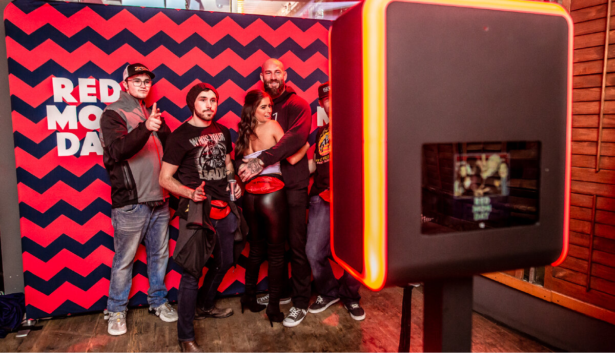 5 guests taking a selfie infront of a Red Monday media wall at brand activation in Whistler, Canada