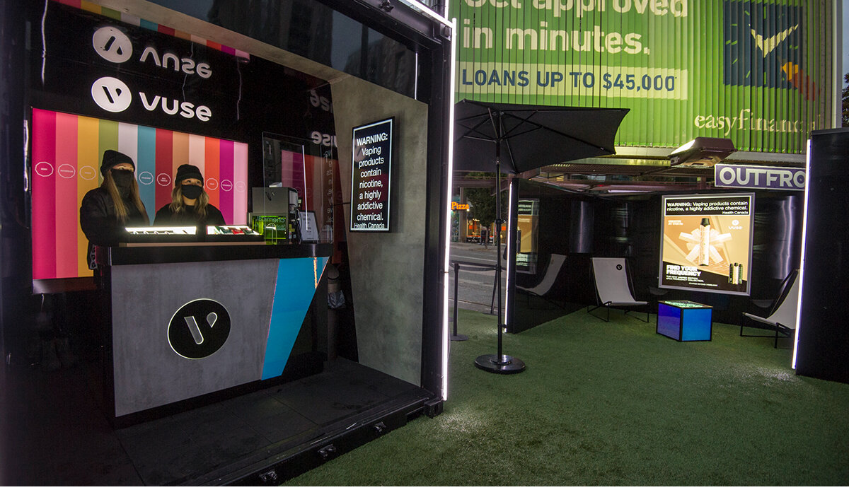 2 brand ambassadors at the Vuse brand activation, all dressed in black, waiting to educate guests on the client's product at a kiosk