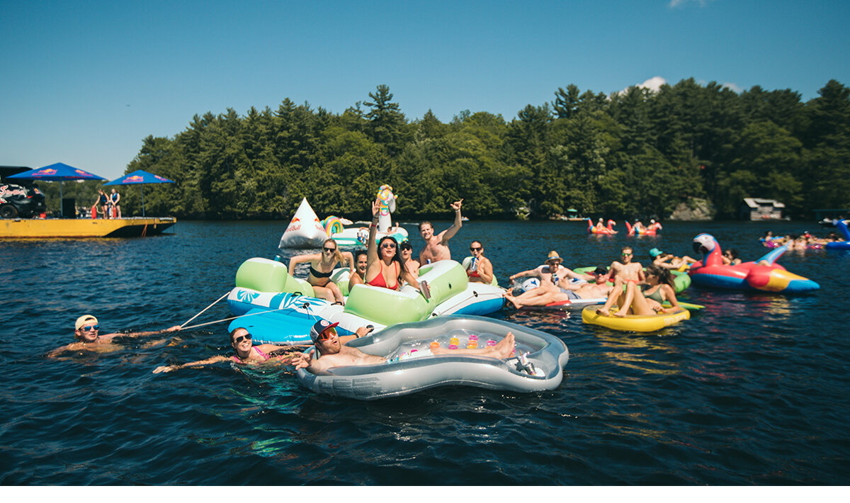 Multiple females and males floating in the water at the Red Bull Open Water brand activation in Muskoka, Ontario