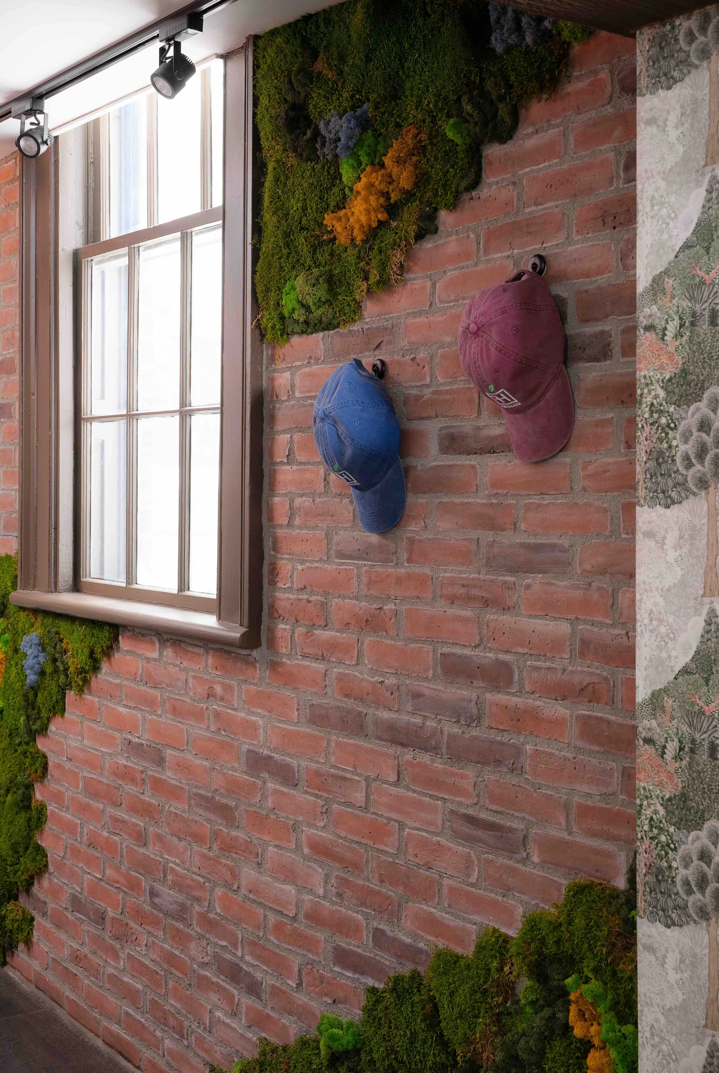 Cafe interior with exposed brick wall and moss feature detail