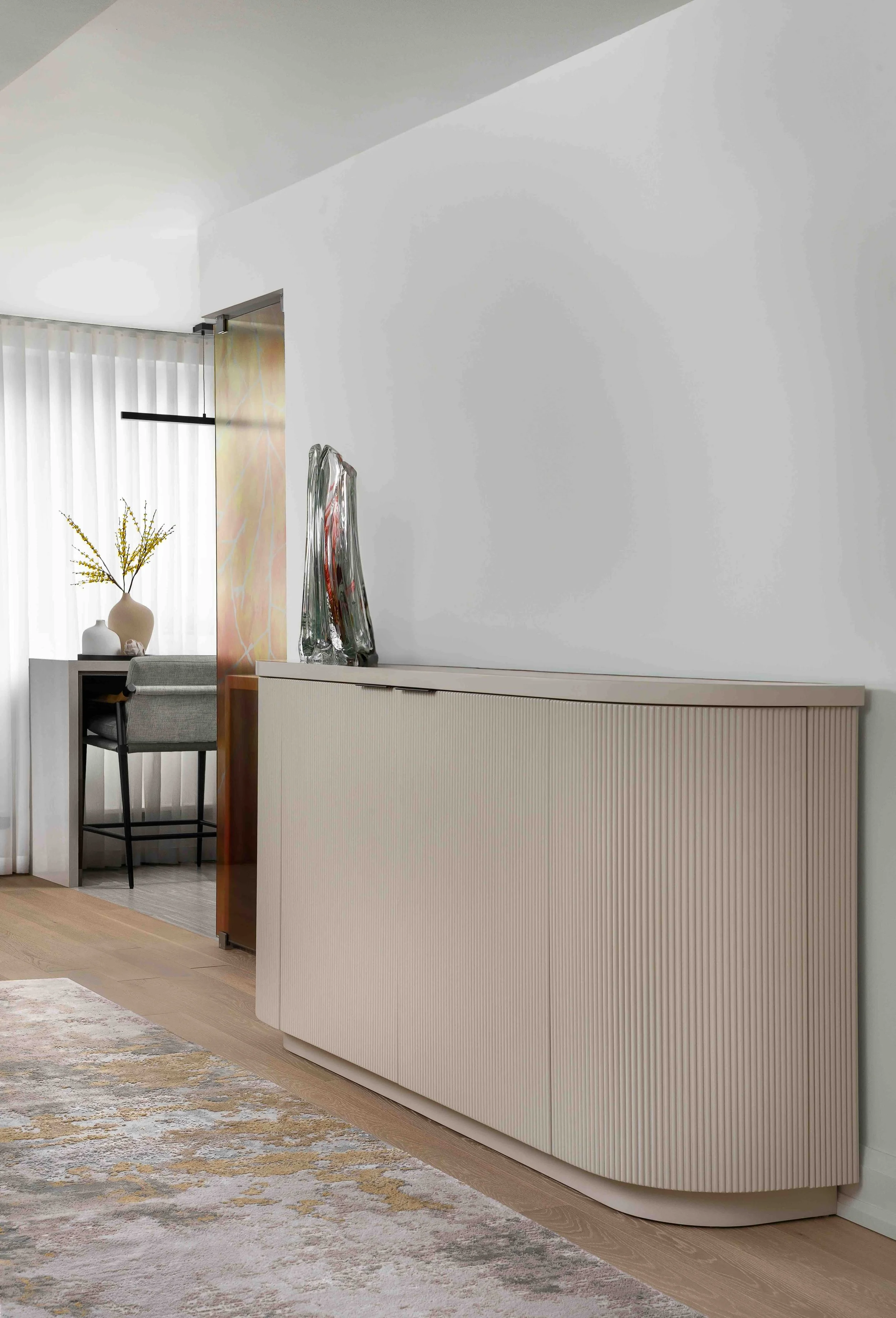 Modern condo credenza with lift TV,  fluted cabinetry and curved custom cabinet design.
