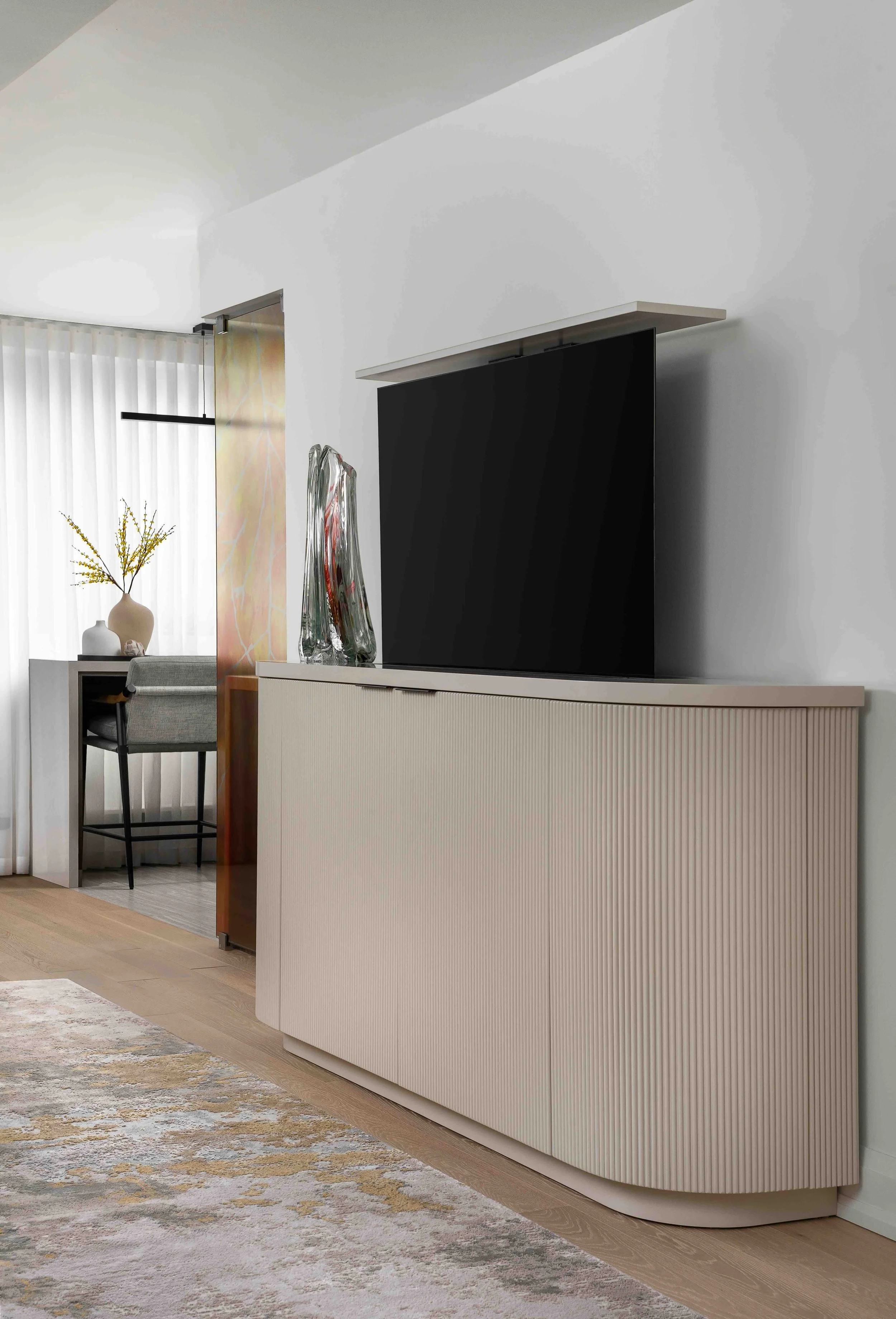 Modern condo console with TV lift, fluted cabinetry and minimalist media wall design.