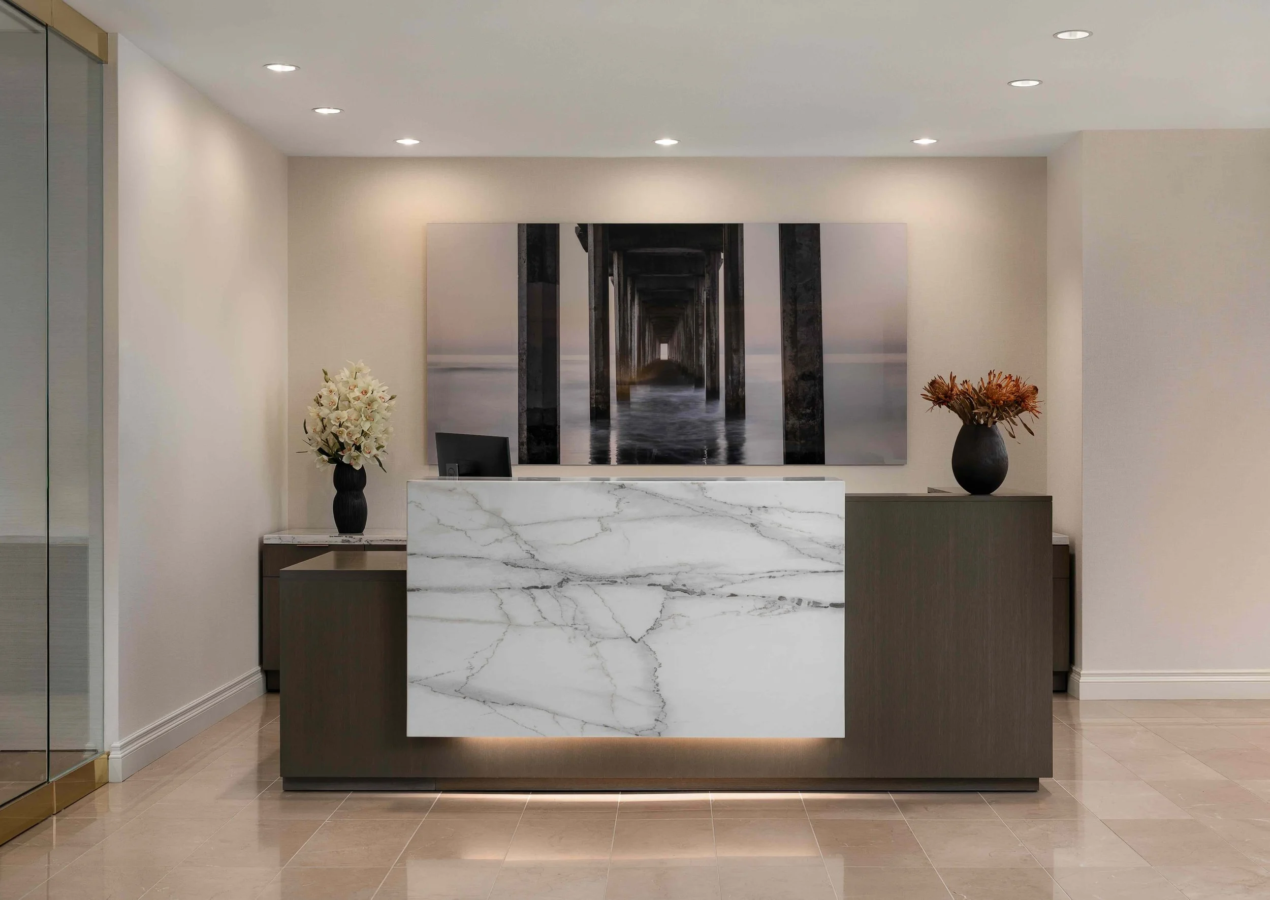 Modern office reception desk with marble front panel and minimalist lobby design.
