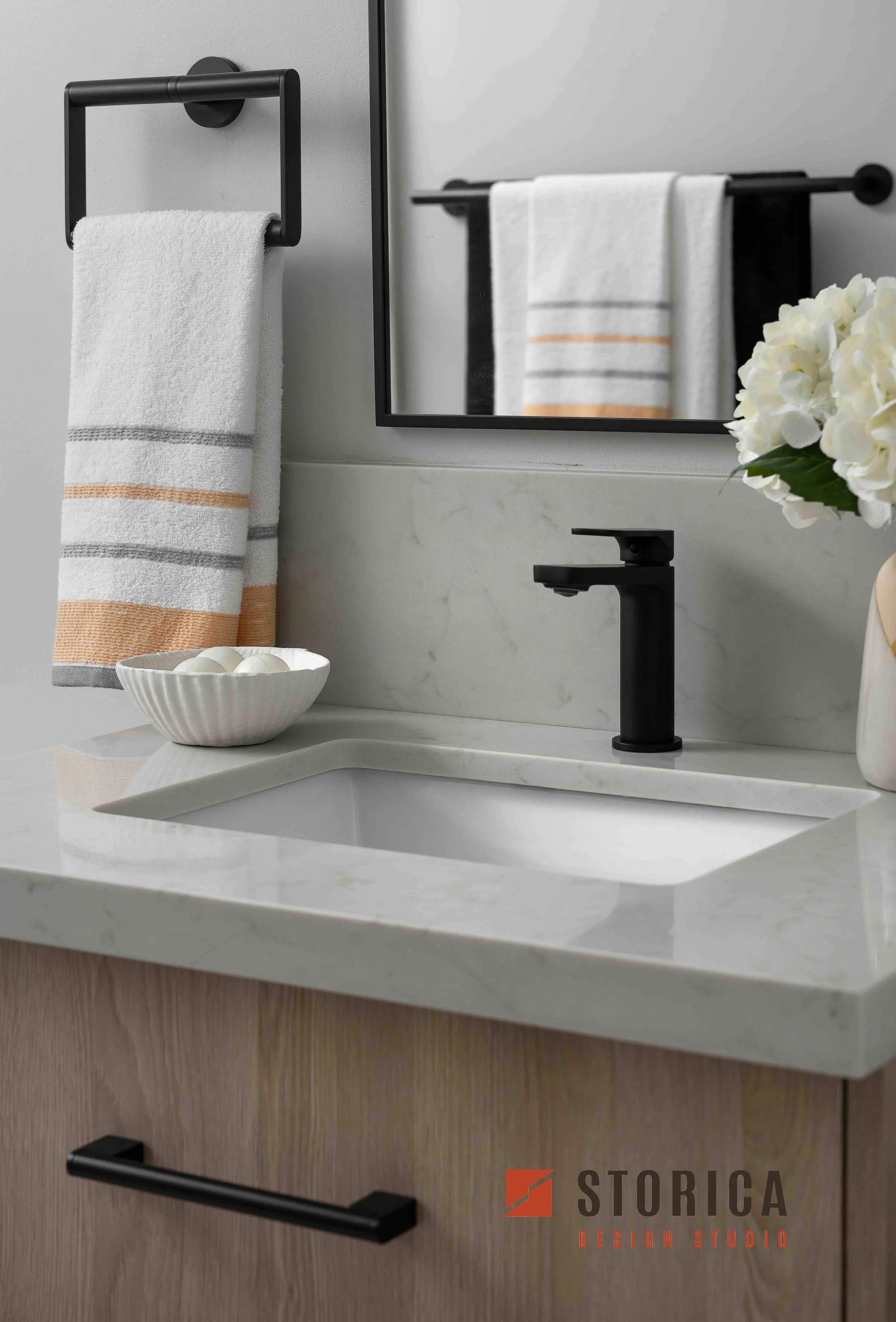 Modern condo bathroom with undermount sink, quartz countertop, and matte black faucet.