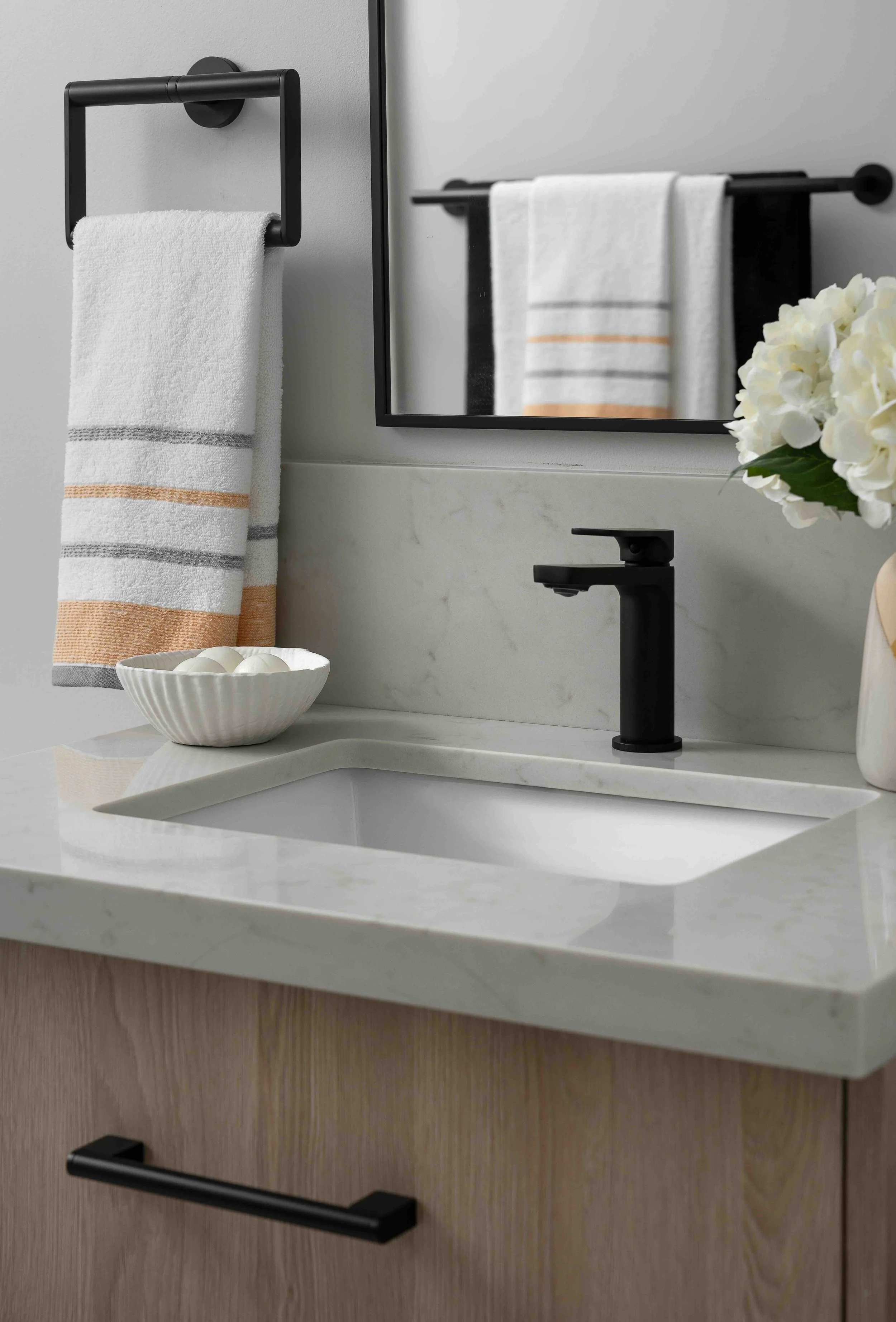 Modern condo bathroom with undermount sink, quartz countertop, and matte black faucet.