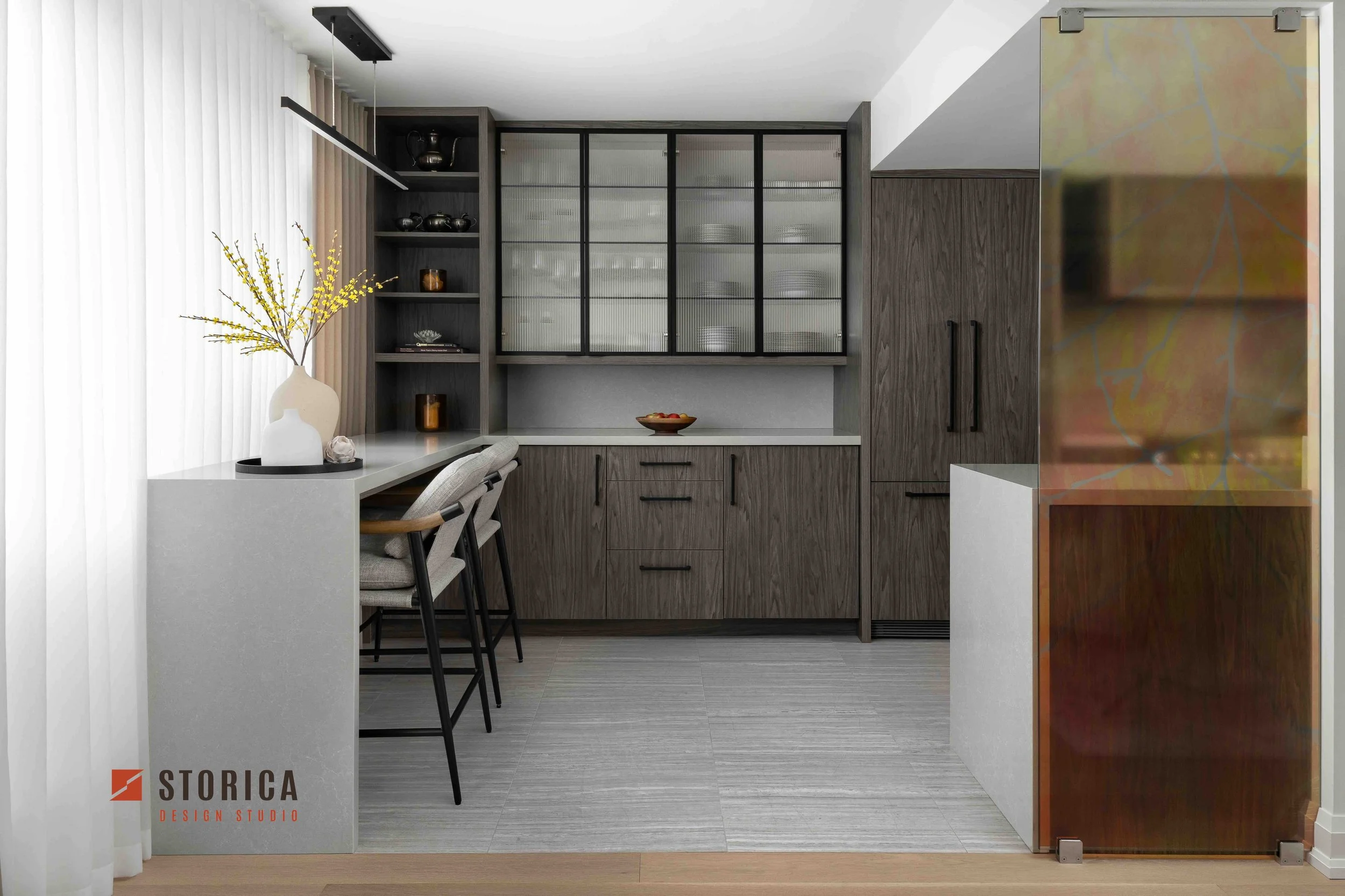 Modern condo kitchen with custom cabinetry, glass display cabinets, and integrated dining bar.