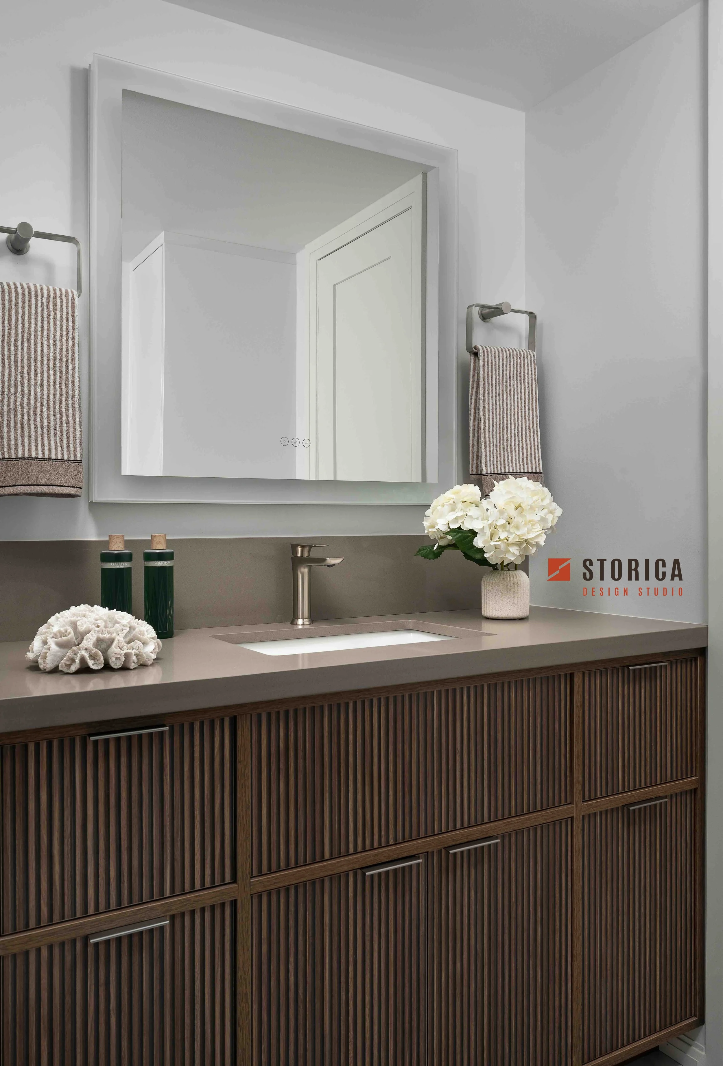 Modern condo bathroom with fluted wood vanity, LED mirror and integrated sink.