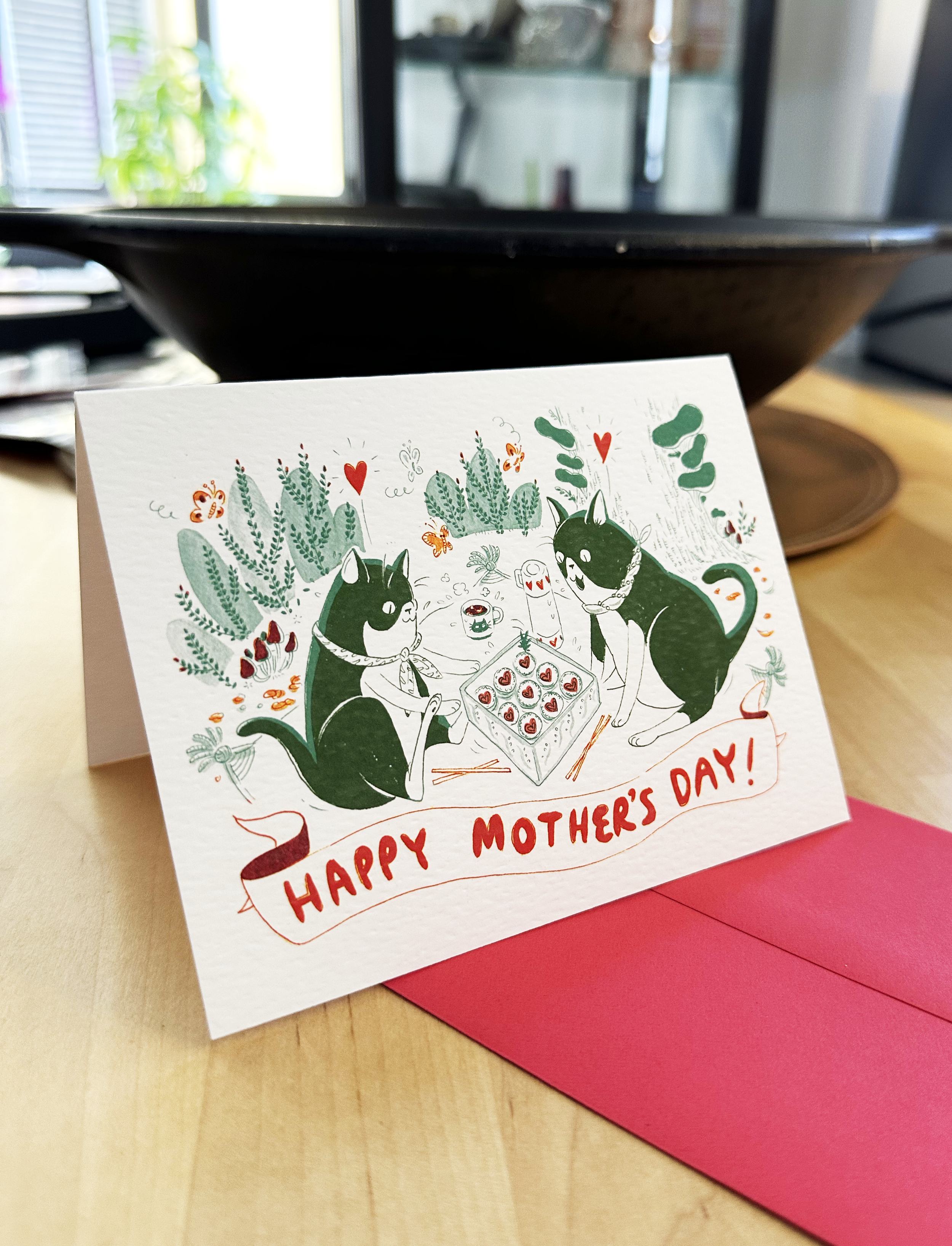 a greetings card of two cats sharing a llunch box