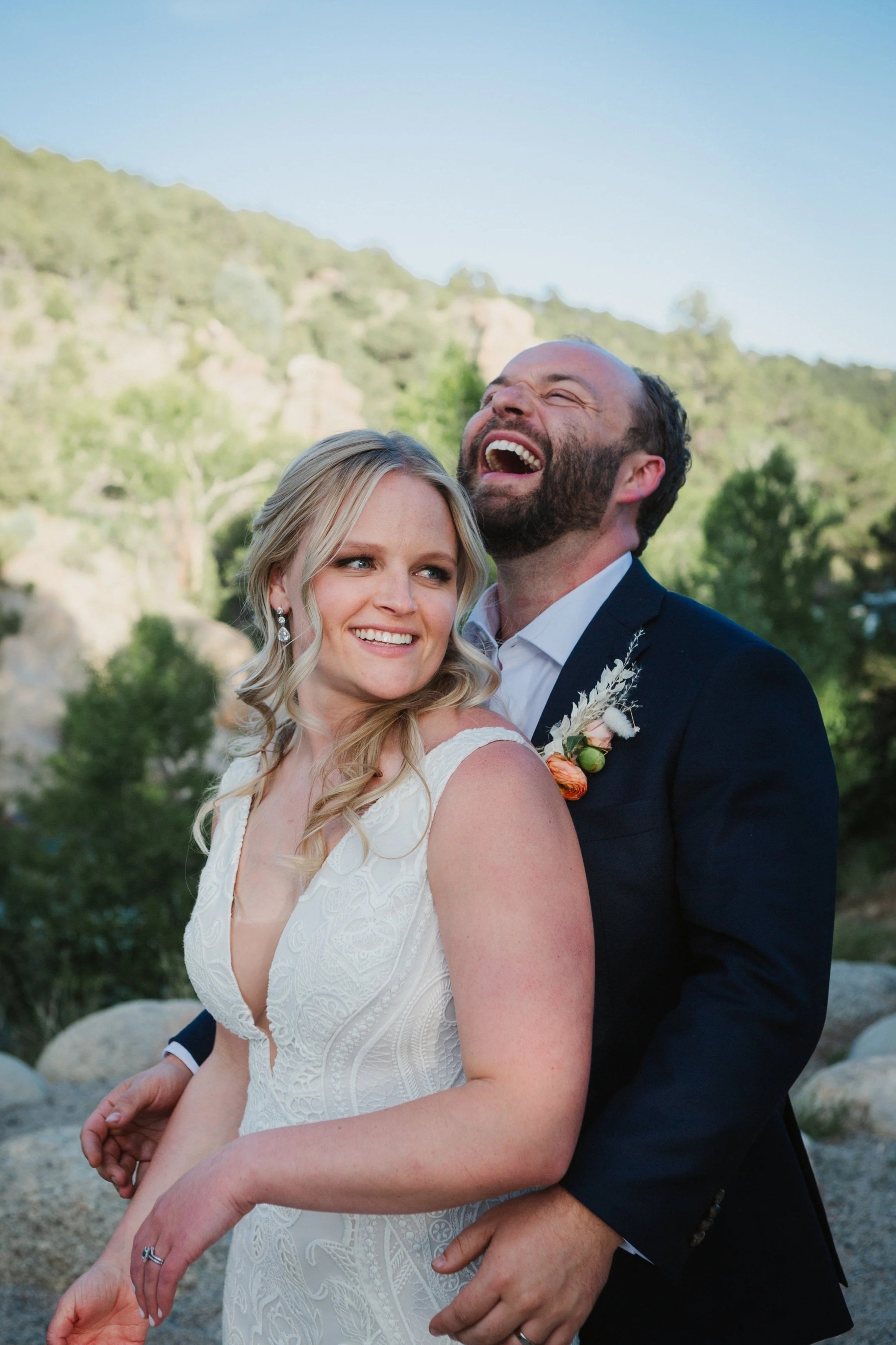 A bride and groom laughing joyously during their wedding portraits at Surf Hotel in Buena Vista, Colorado.