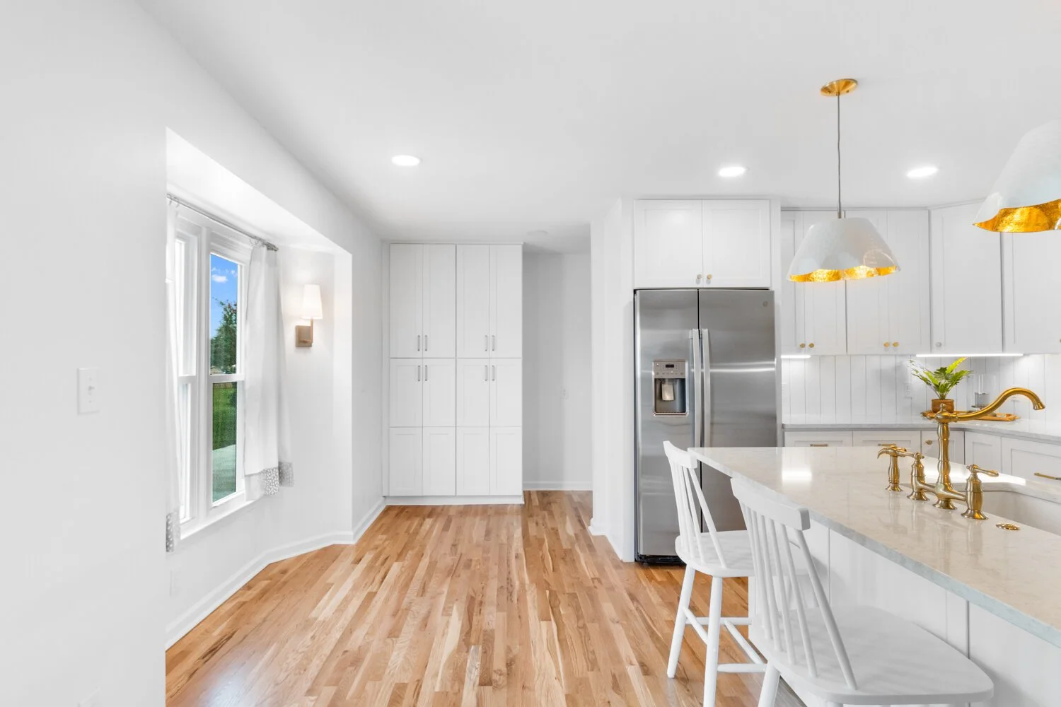 A corner of an all-white modern kitchen.