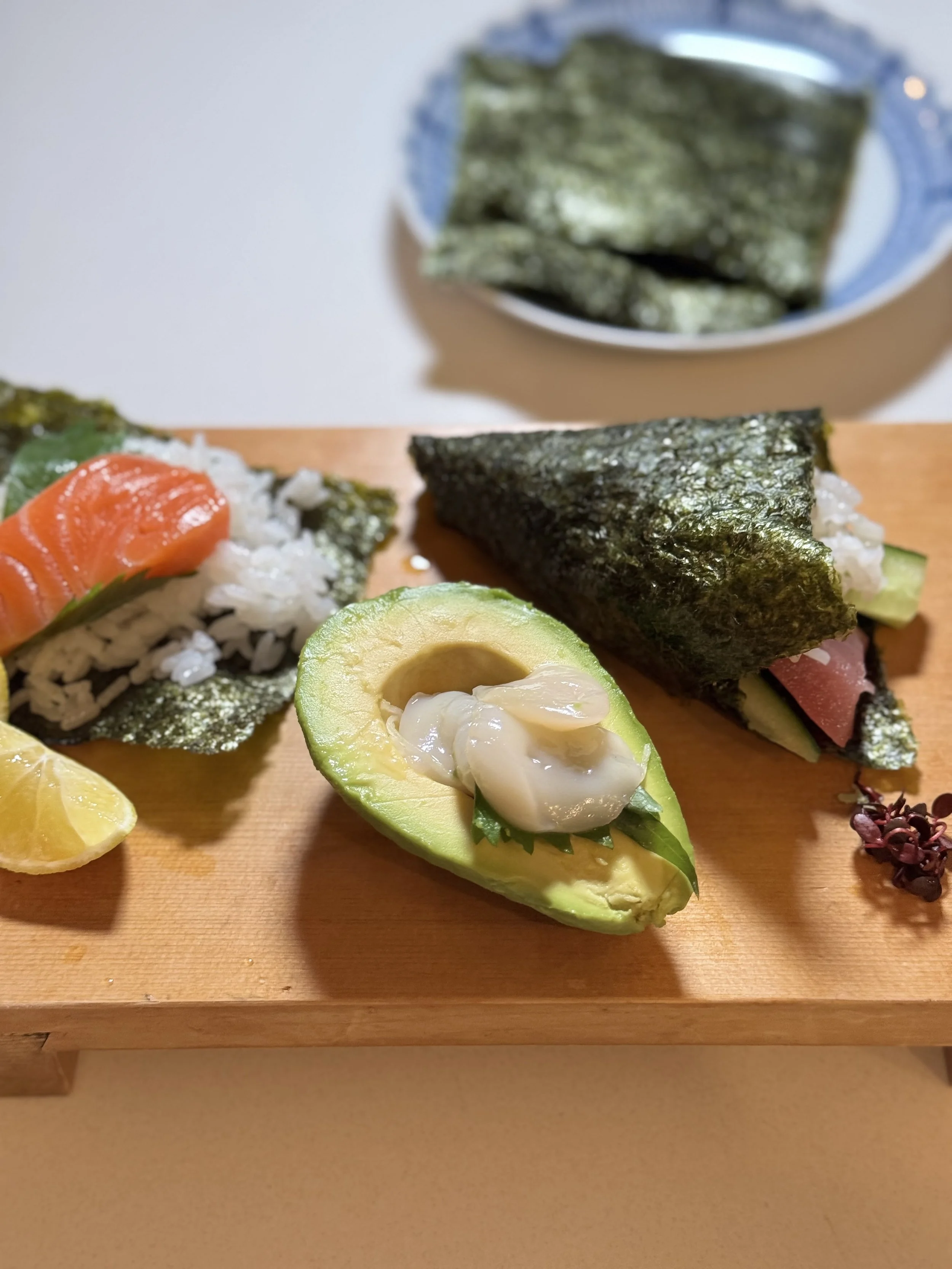 Homemade temaki sushi with sashimi, avocado, cucumber and nori.