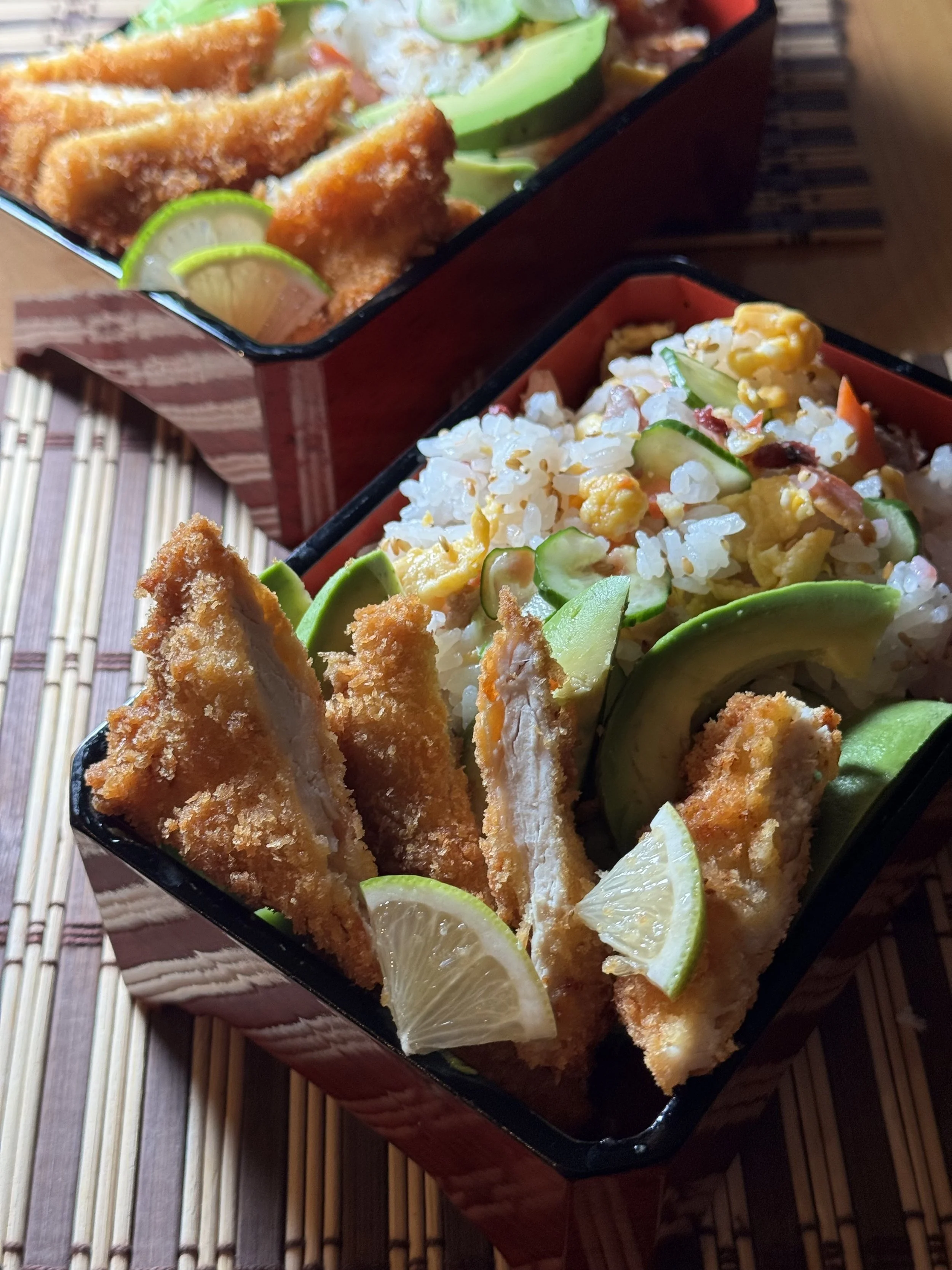 Sushi rice with salmon, egg and cucumber served with crispy chicken and avocado.
