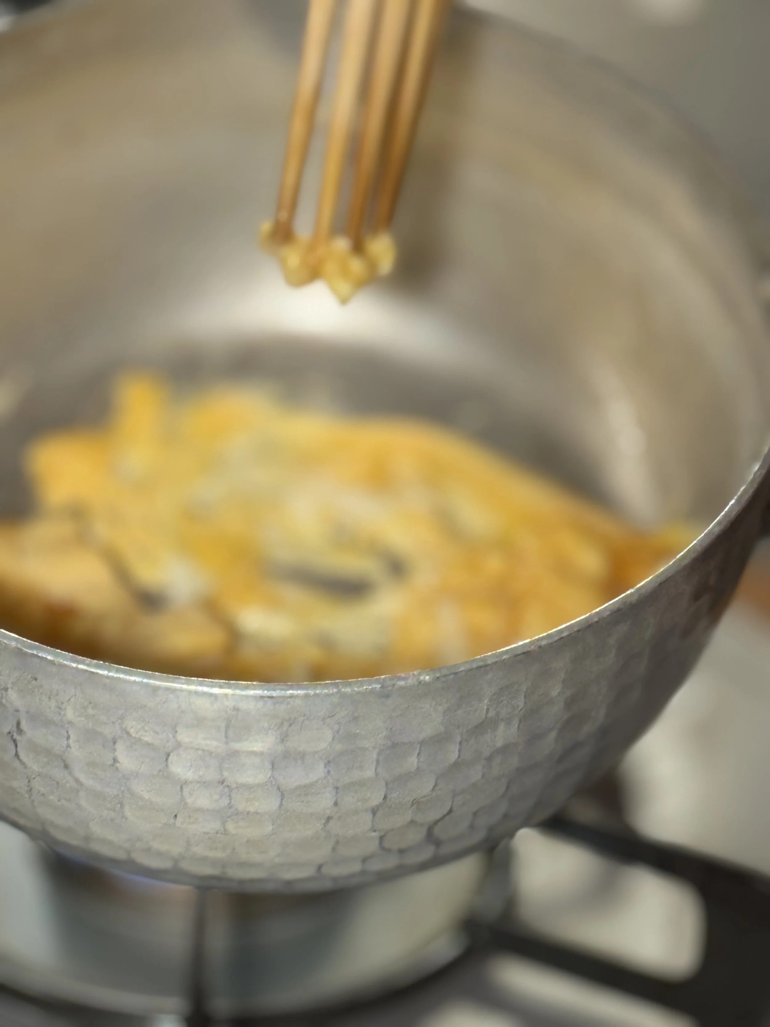 Making soft egg flakes with chopsticks in a pan.