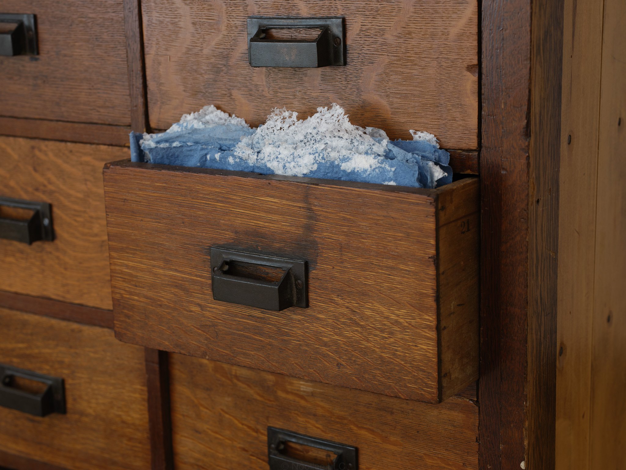 Installation Detail: The Day Lasts More Than a Thousand Sunsets, 2023-2025Glass, rocks from Israel, vintage furniture, hand made recycled denim, cotton and abaca paper , digital and electrical components, three channel video projections presented in 