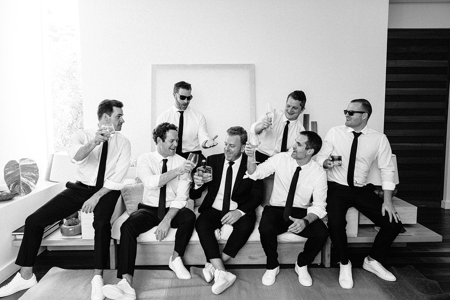 09 fun photography of groom with his groomsmen drinking tequila sitting on a couch at Rosewood Mayakoba Riviera Maya Cancun.JPG